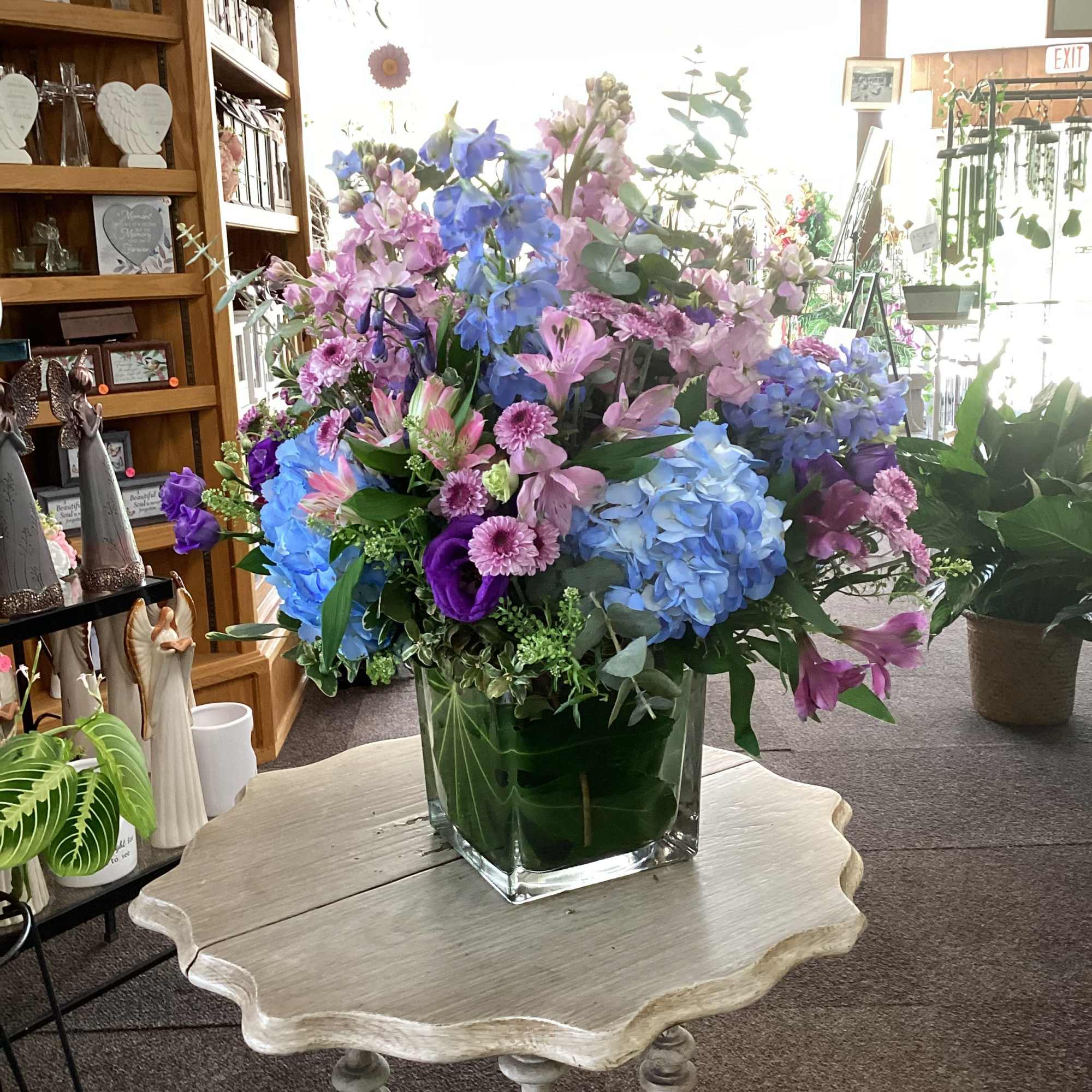 Square cube leaf lined and filled with blue hydrangea, lavender stock, blue
