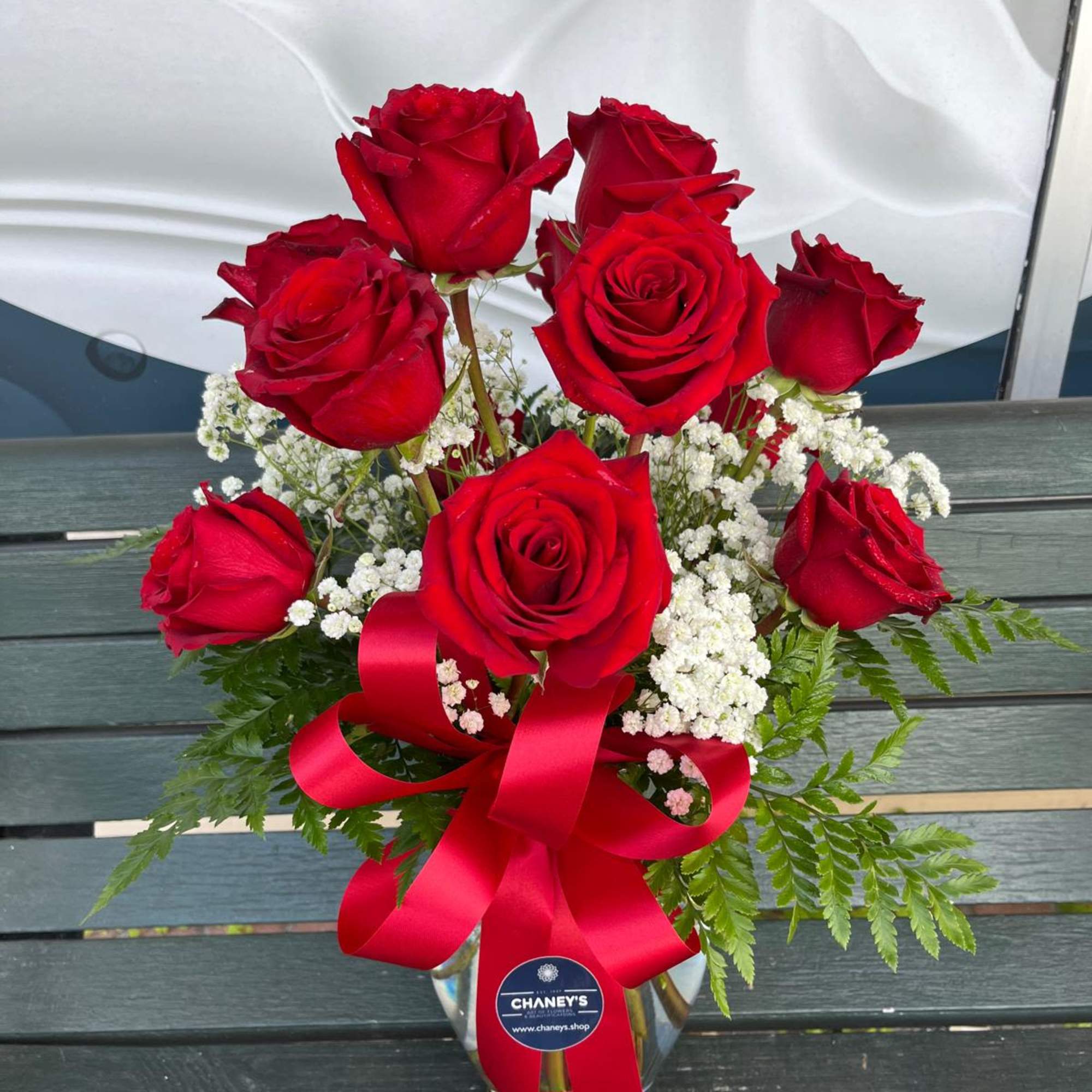 Bouquet of red roses with white baby's breath in a glass vase