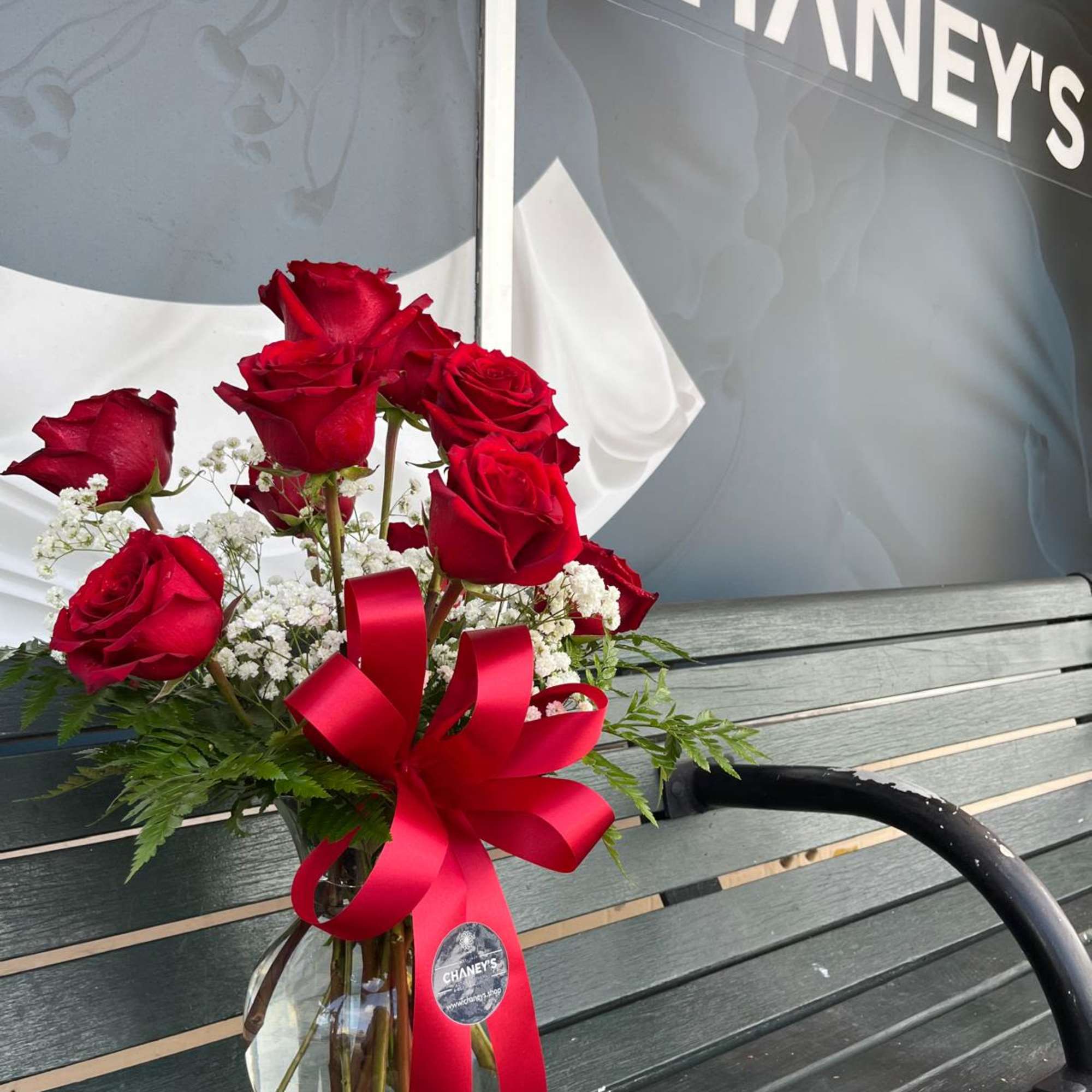 Red roses in a glass vase with a red ribbon