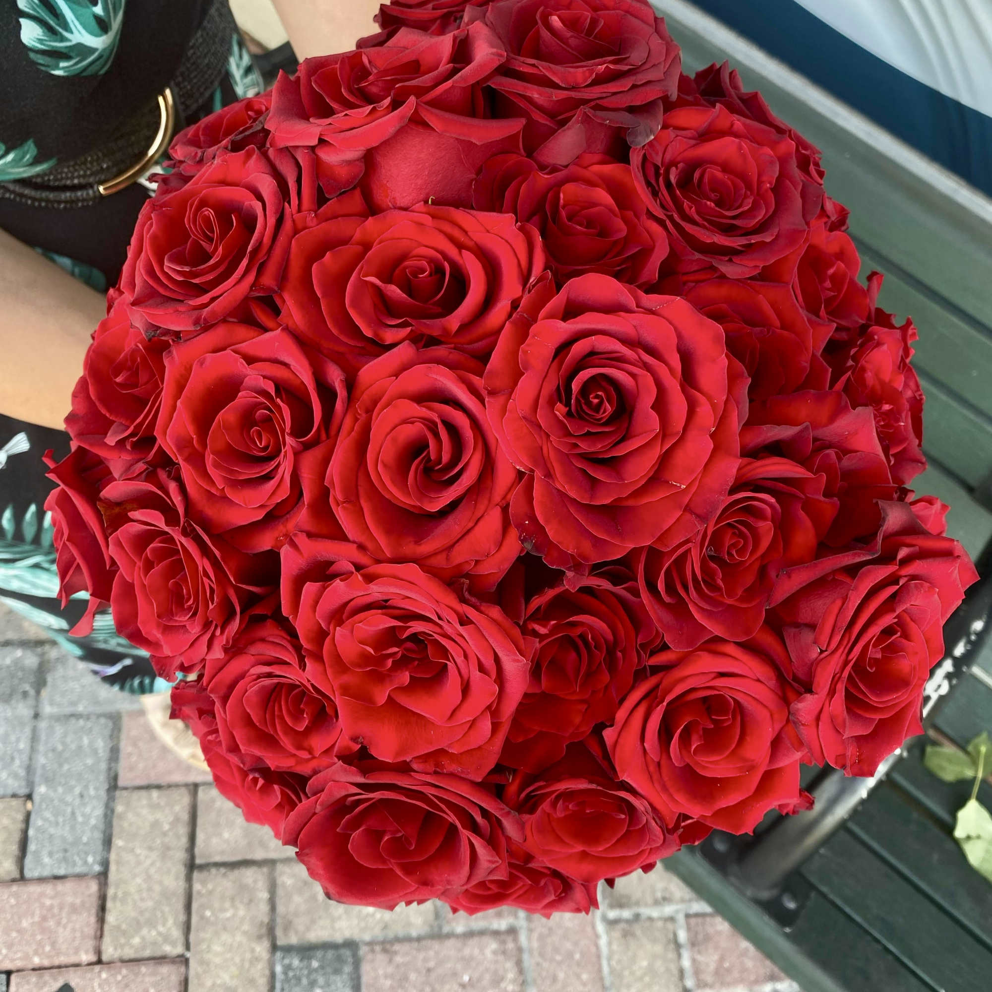 Large bouquet of red roses held in someone’s arms