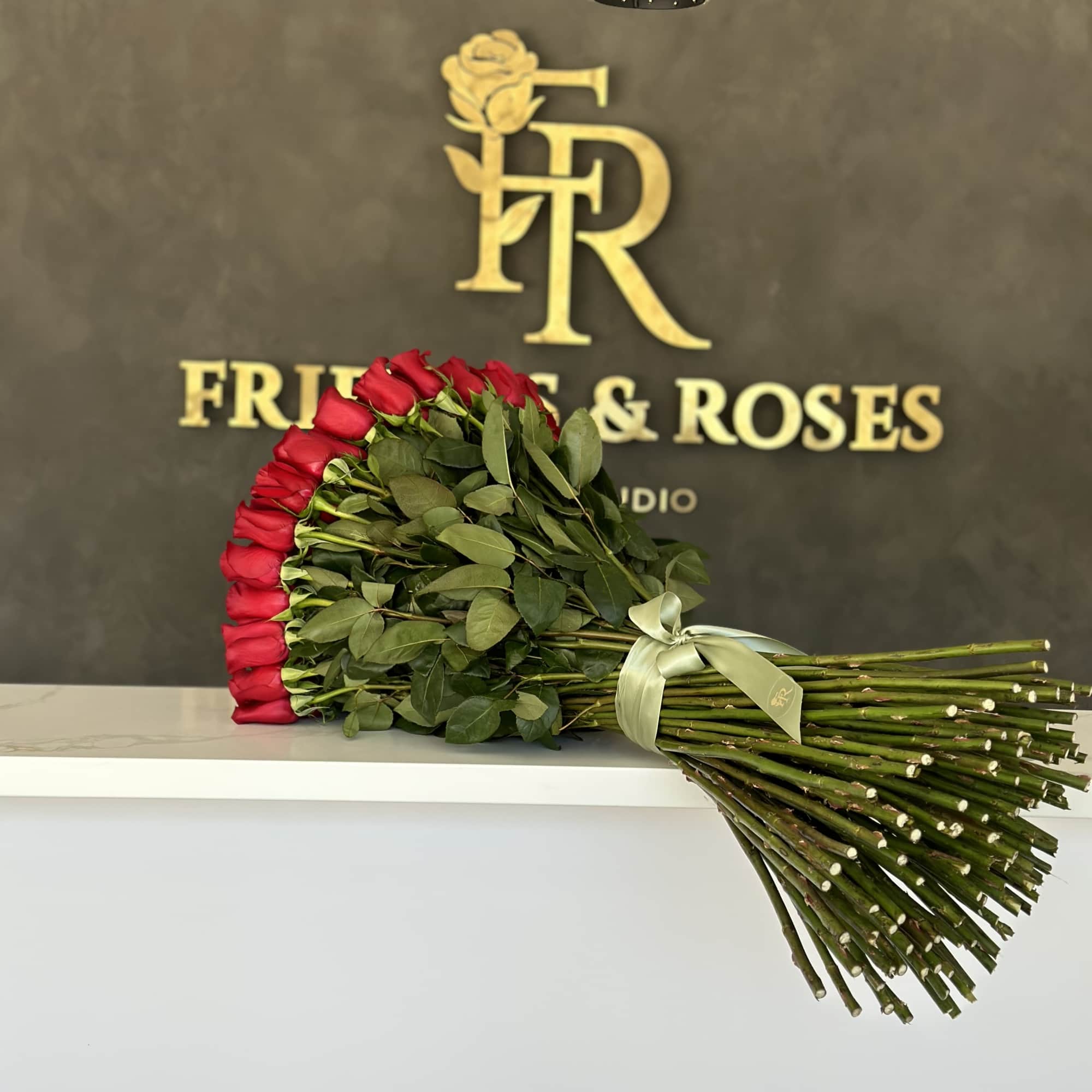 Long-stem red rose bouquet tied with a pale ribbon