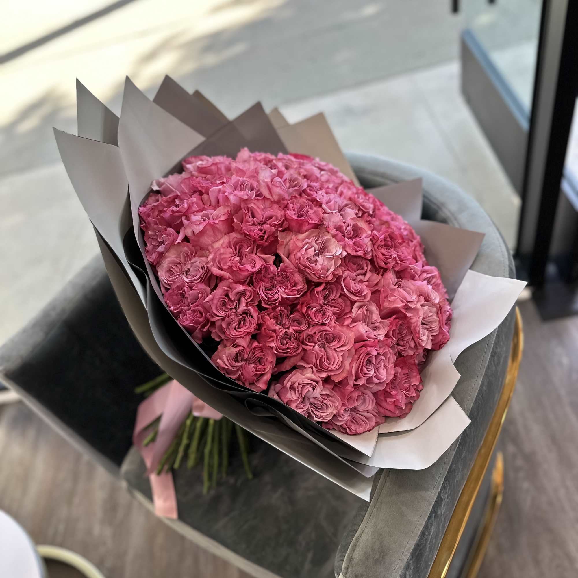 Large bouquet of pink roses wrapped in gray and white paper