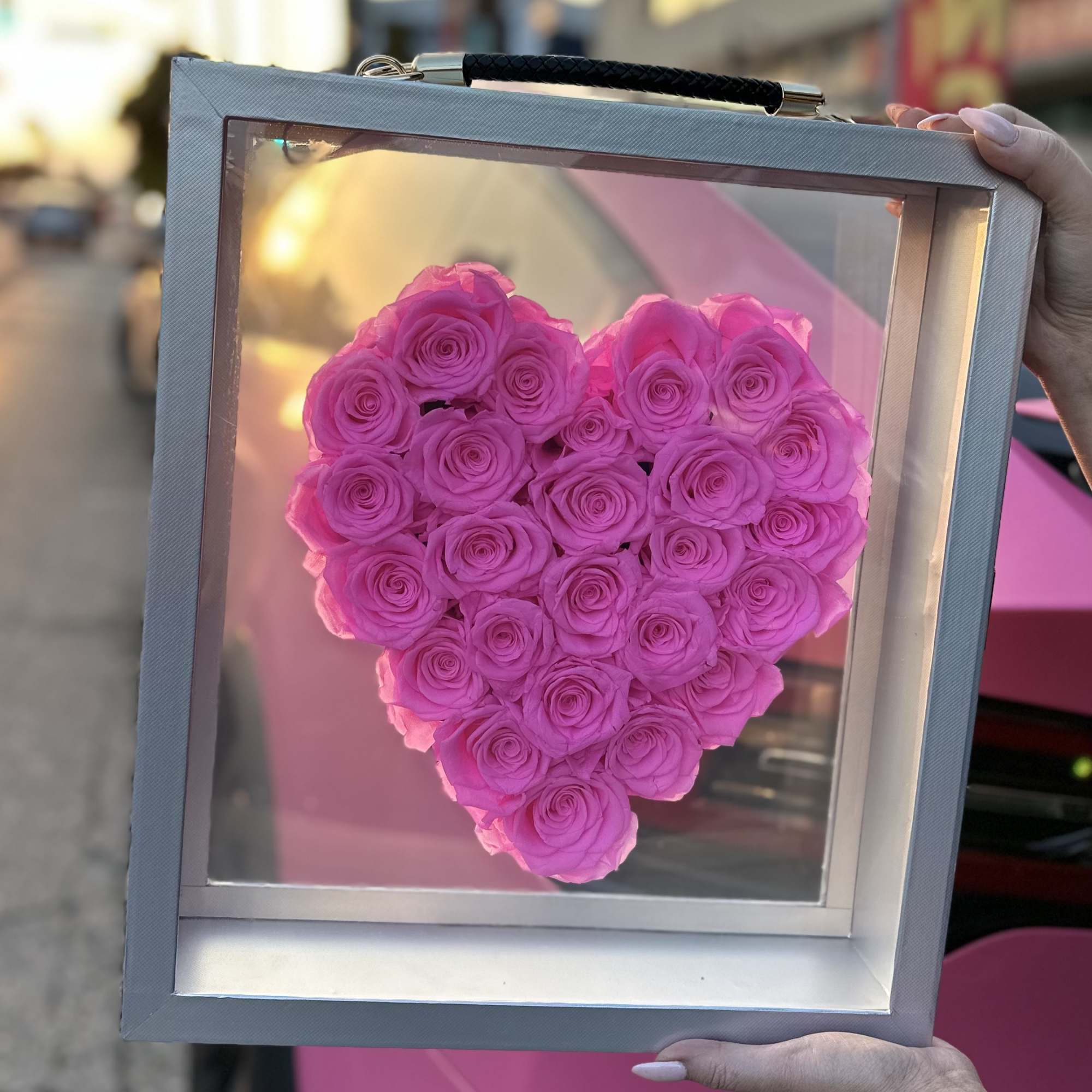 Heart-shaped arrangement of pink roses in a shadow box frame