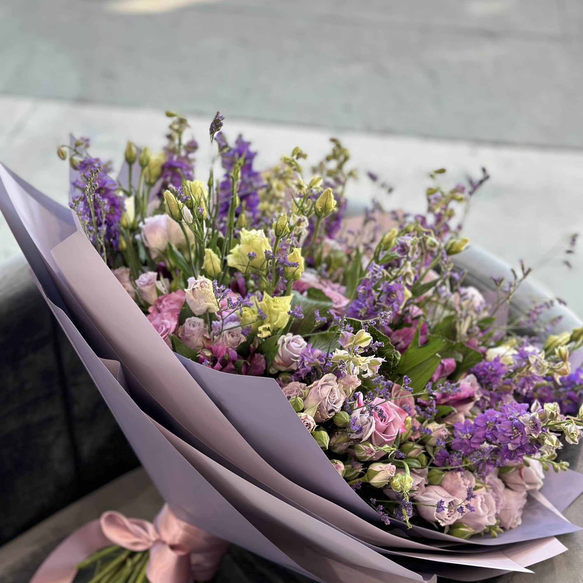 Lavender and pink bouquet with small roses and purple filler flowers