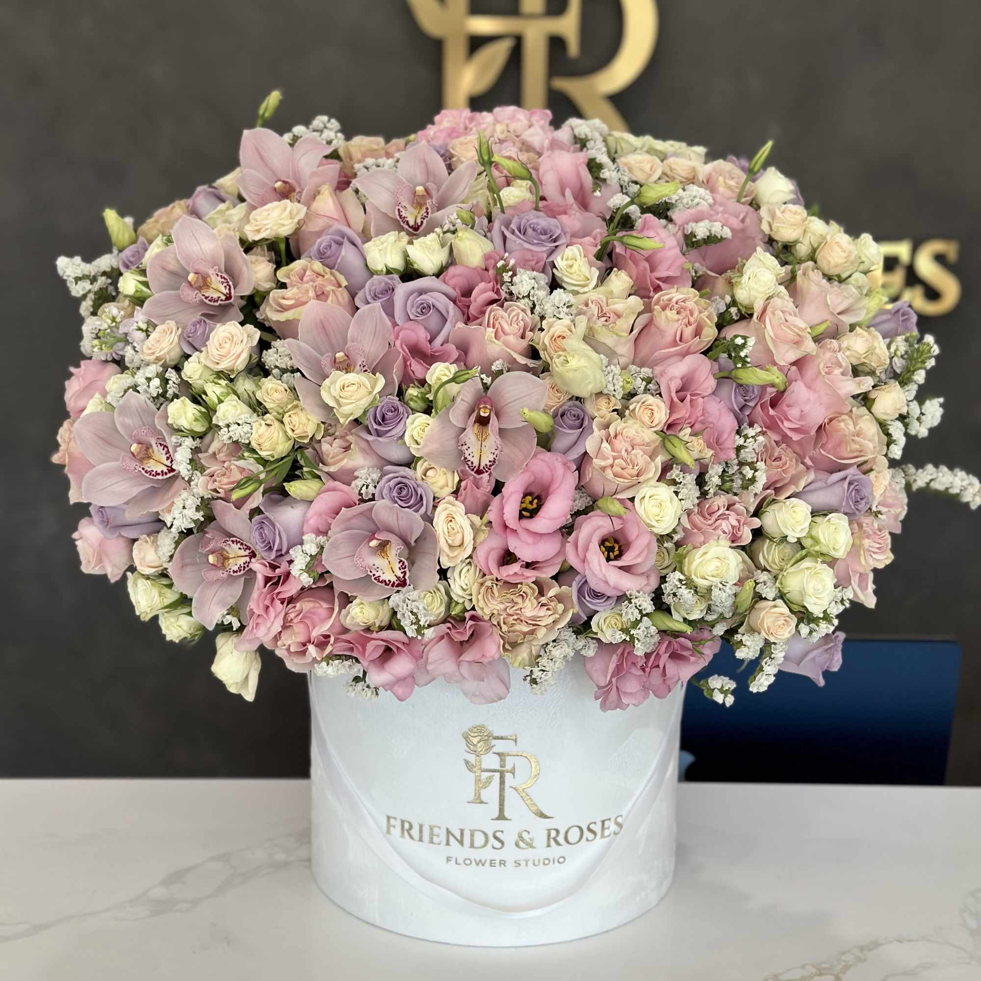 Large pastel bouquet in a white hatbox with pink and lavender blooms