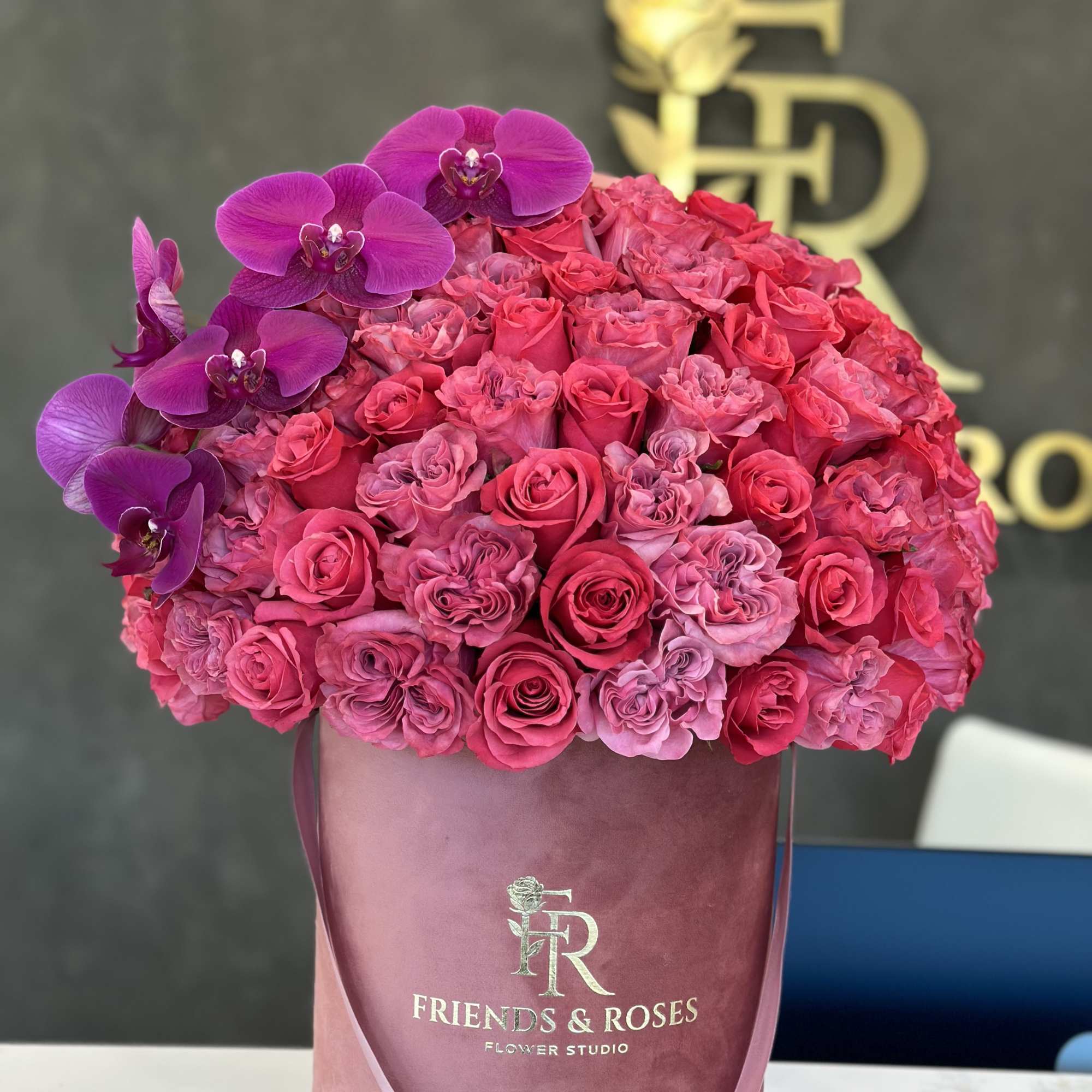 Pink and purple rose bouquet in a velvet hatbox with orchids