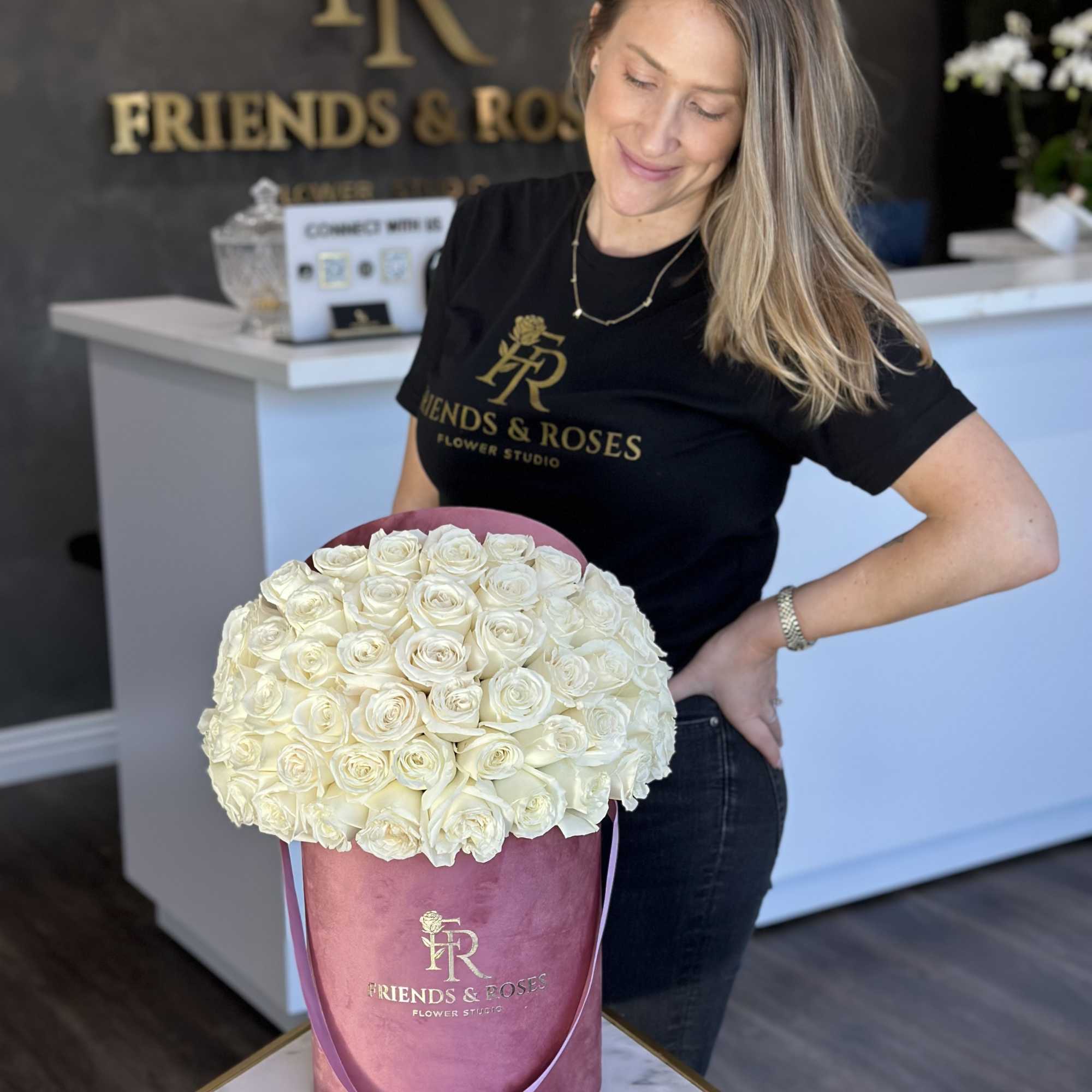 Large white rose arrangement in a pink hat box