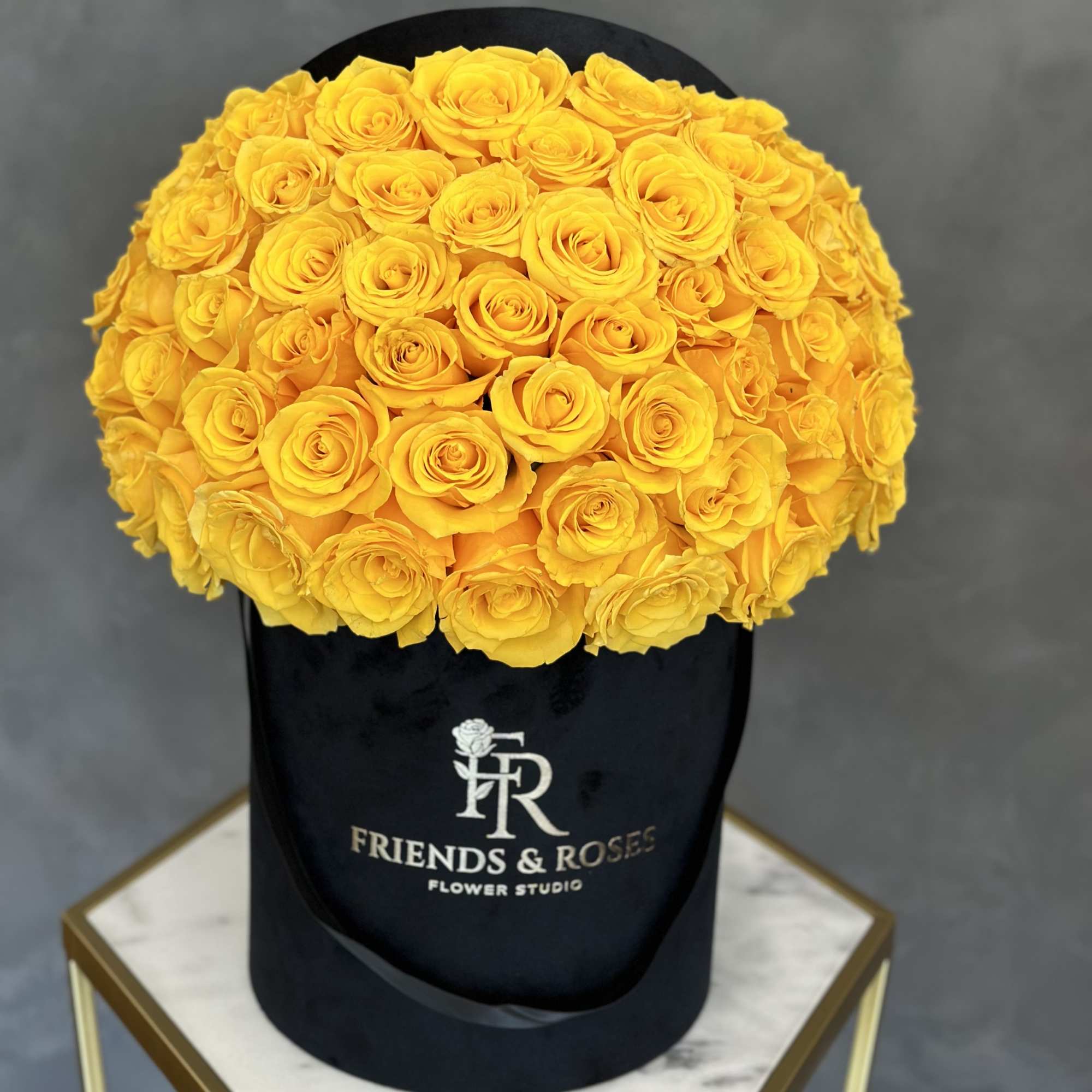 Large bouquet of yellow roses in a black hat box