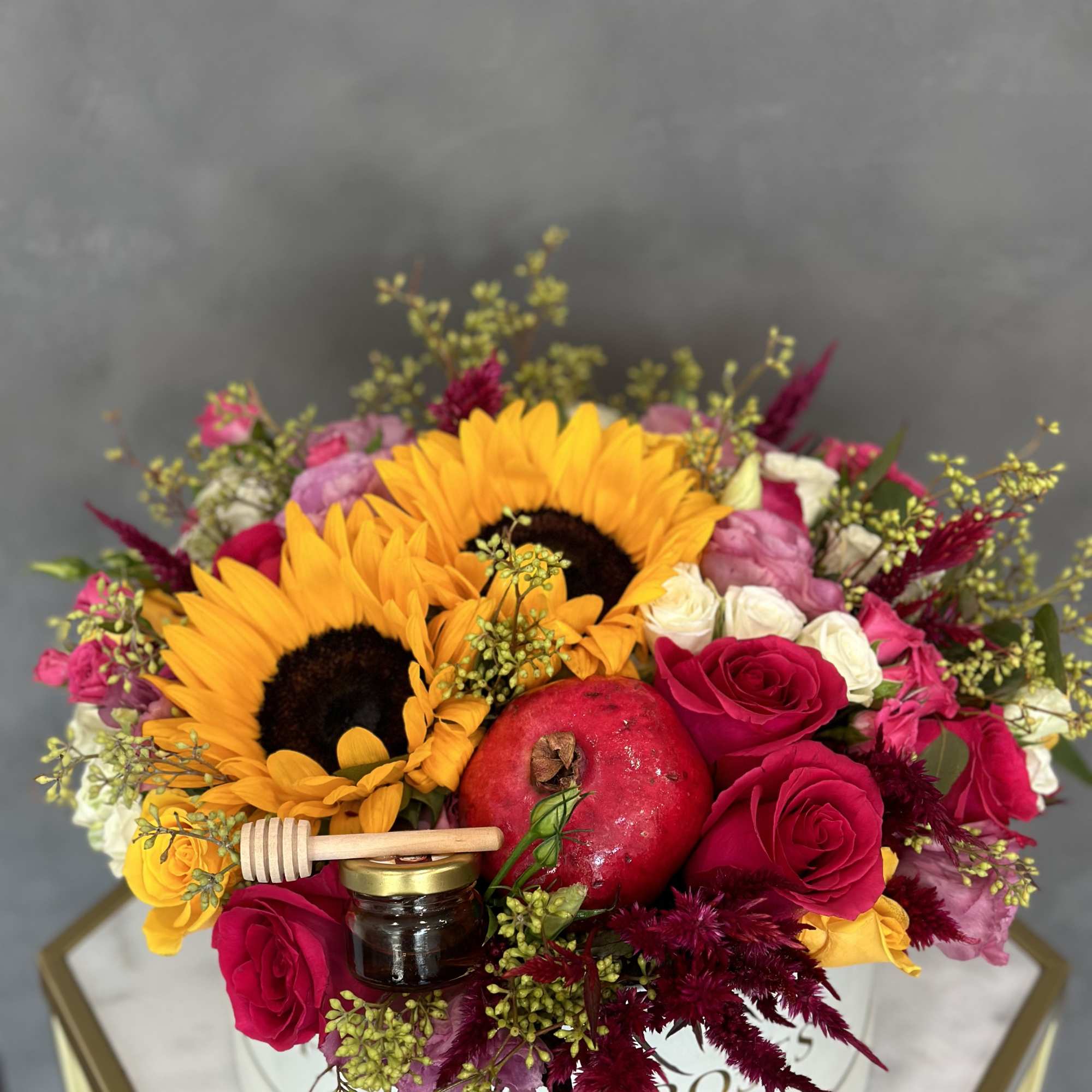 Bouquet with sunflowers, red roses, and a pomegranate in a round box, photo 2 of 3