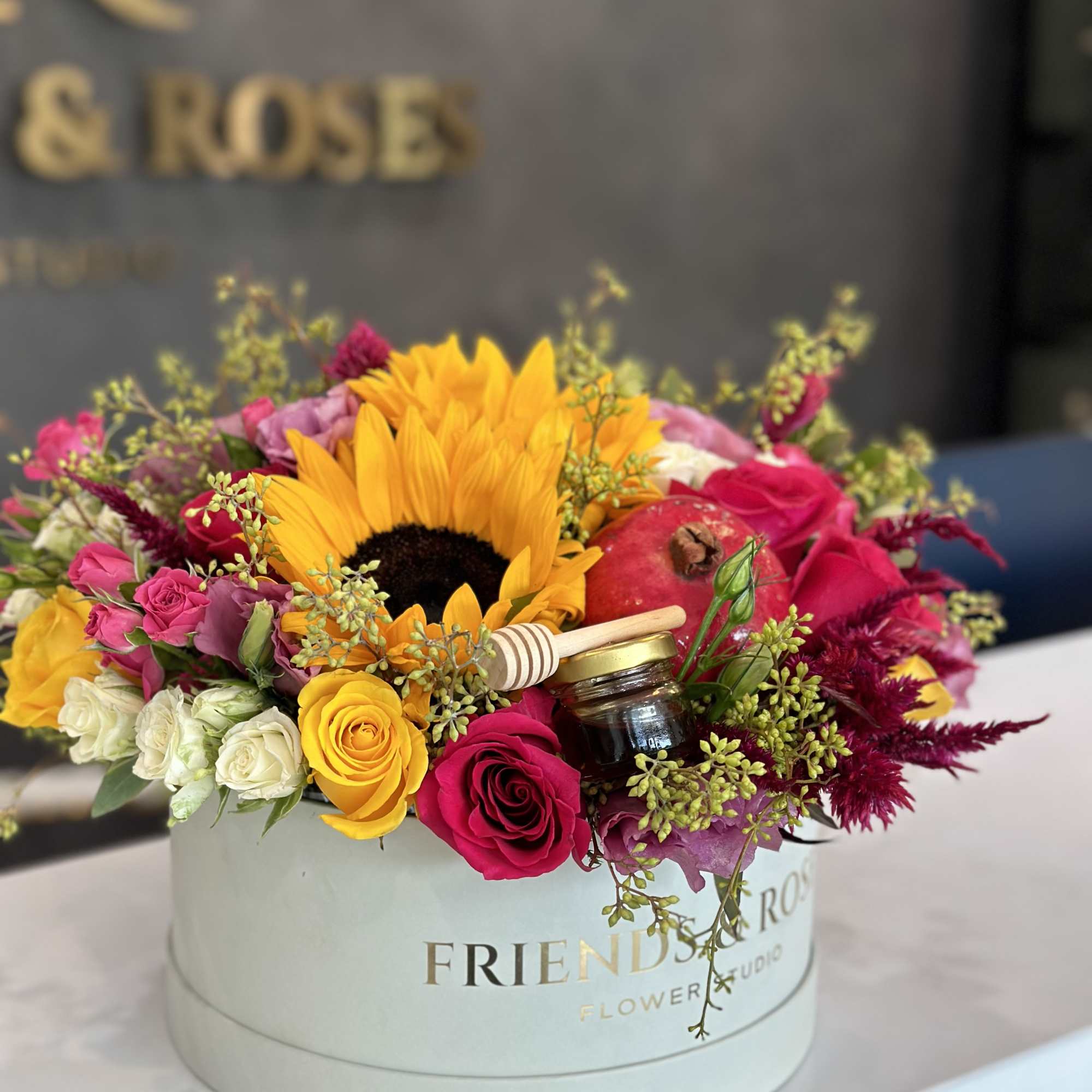 Colorful flower box with sunflowers, roses, and a pomegranate