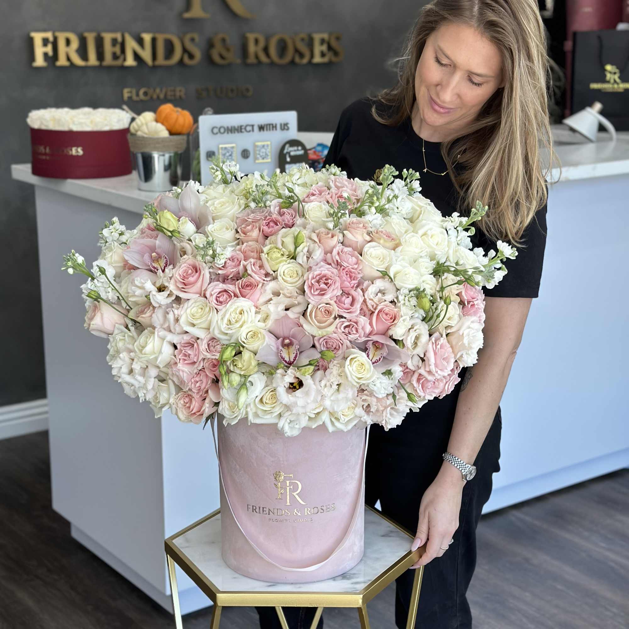 Large pink and white rose arrangement in a blush hatbox