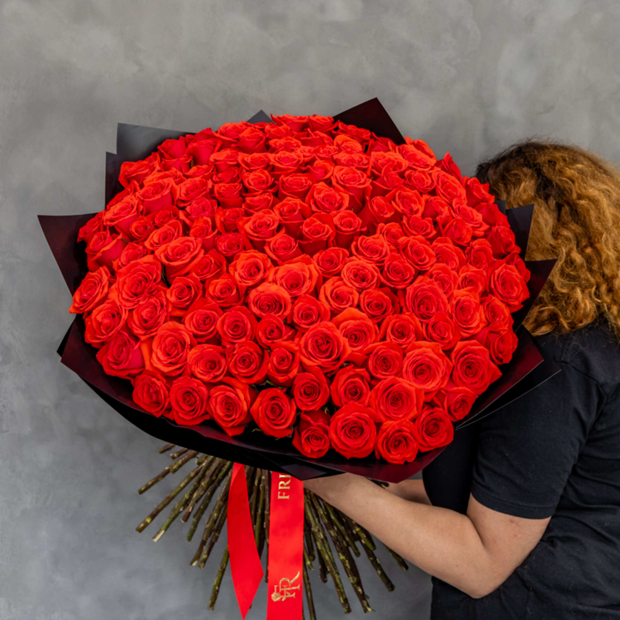 Large bouquet of red roses wrapped in black paper
