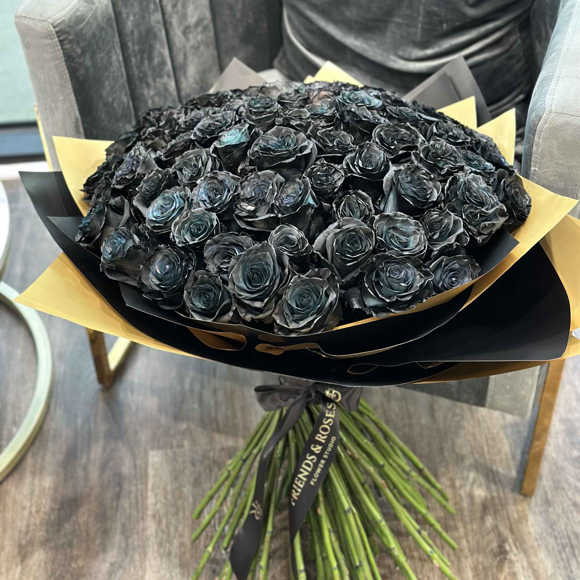 Large bouquet of black roses wrapped in black and gold paper