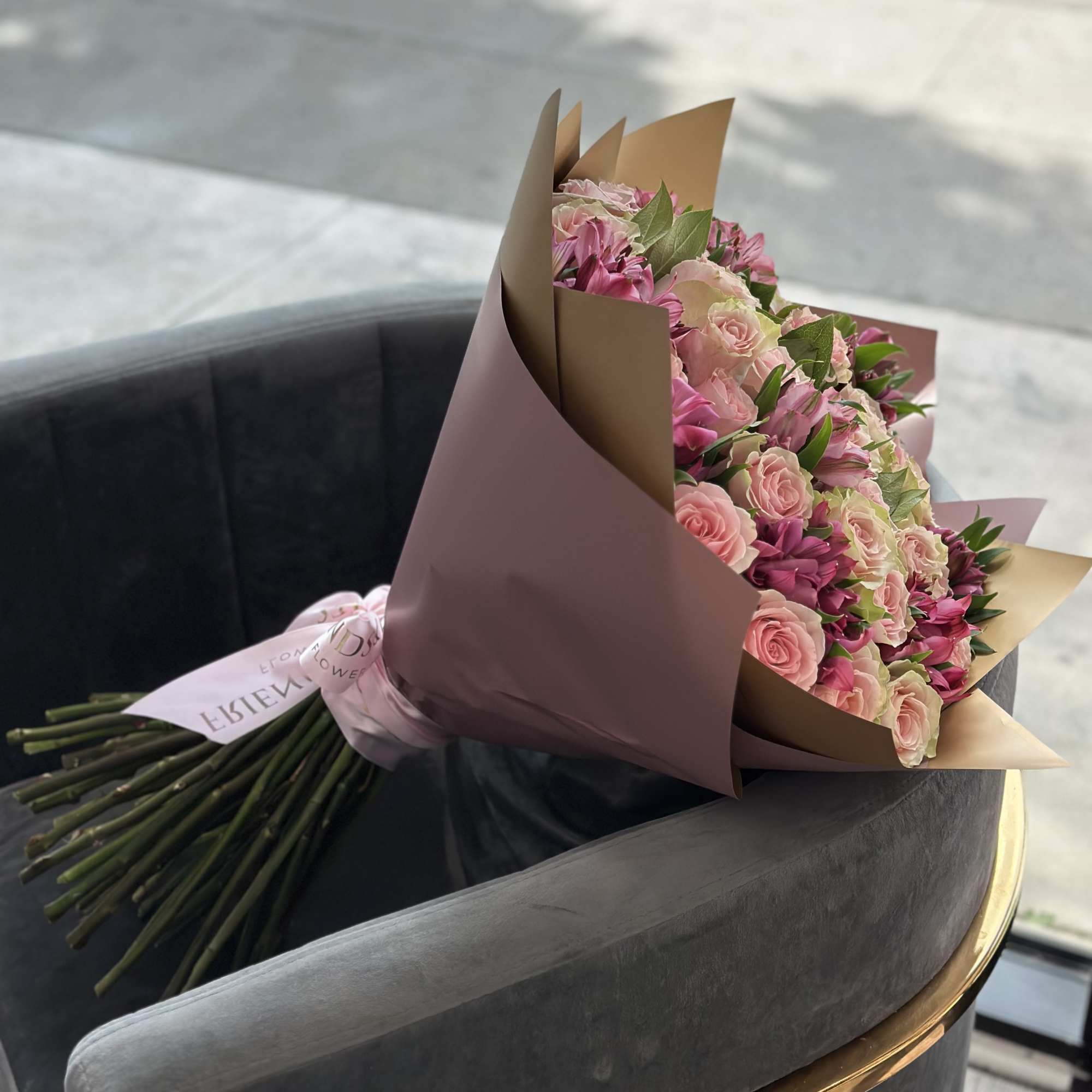 Bouquet of pink roses and pink alstroemeria wrapped in mauve paper