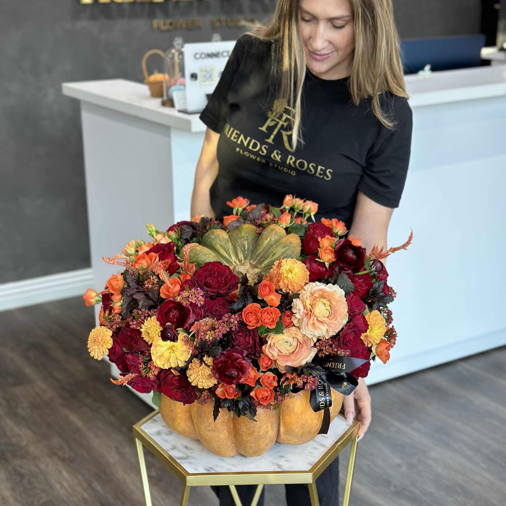 Large mixed flower arrangement in a pumpkin-shaped container