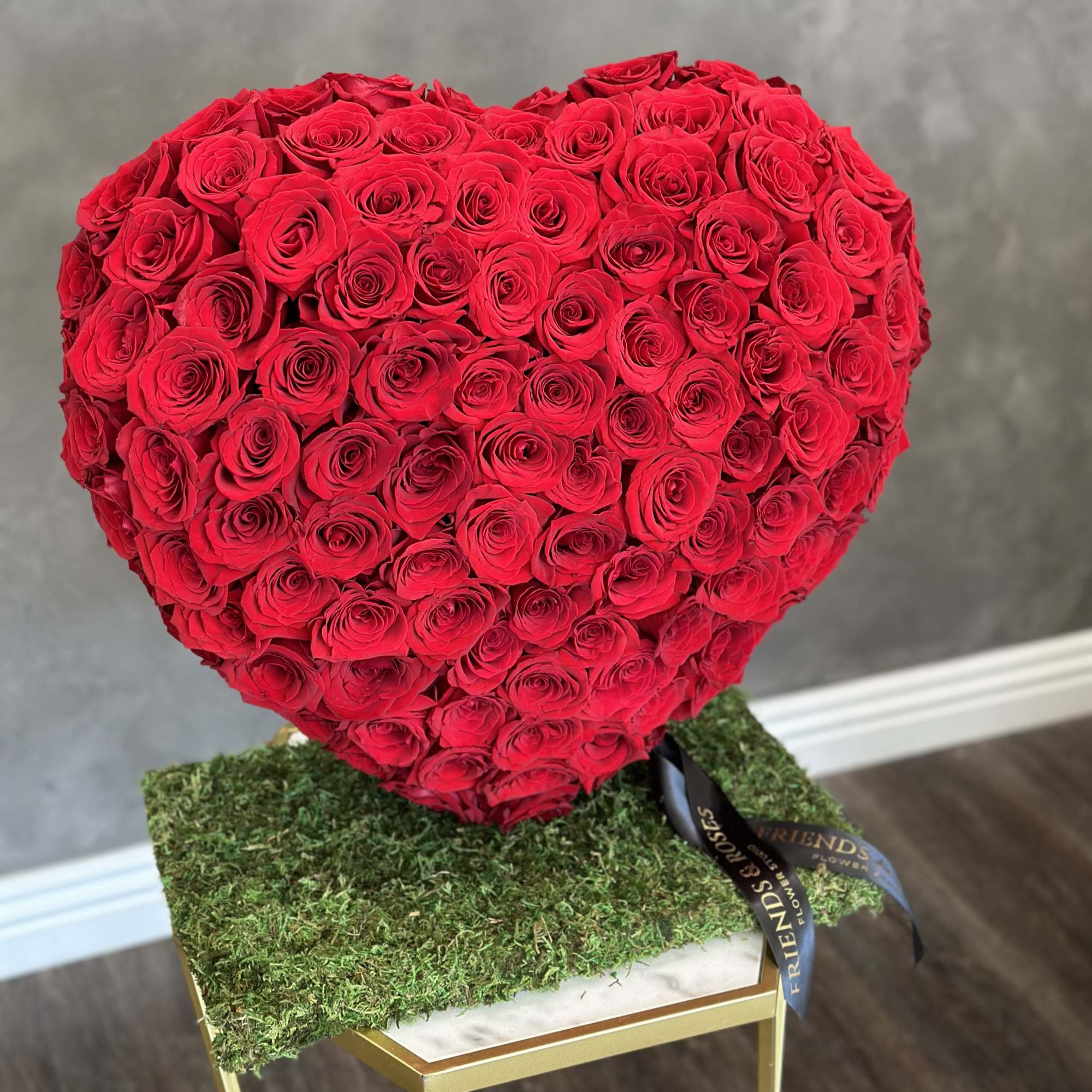 Heart-shaped arrangement of red roses on a moss-covered base, photo 2 of 2