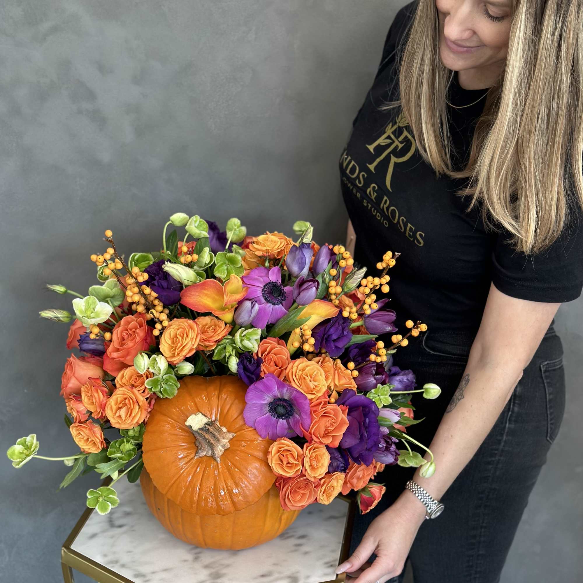 Orange pumpkin centerpiece with purple and orange flowers, photo 2 of 2