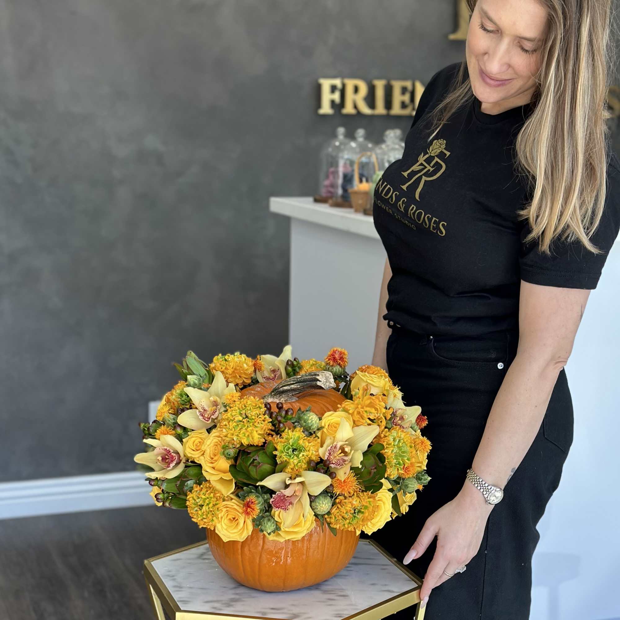 Pumpkin centerpiece with yellow flowers and orchids, photo 3 of 3