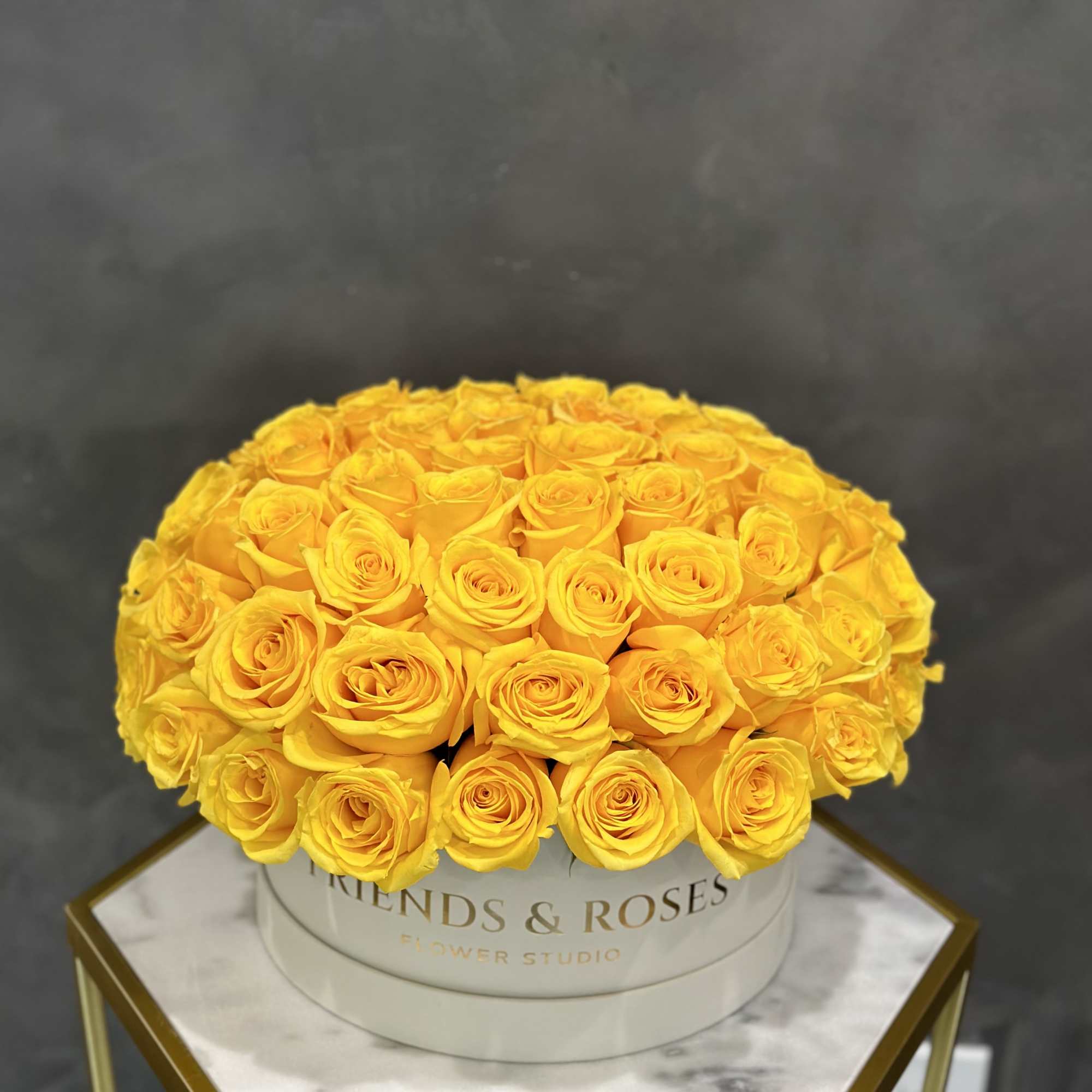 Round bouquet of yellow roses in a white hat box