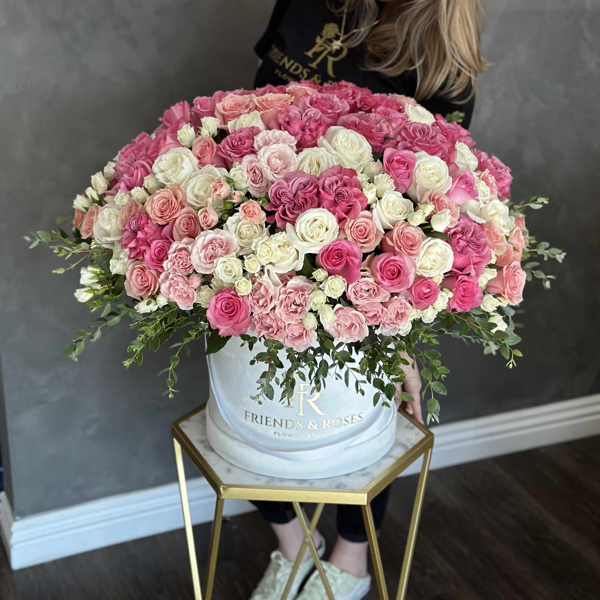 Large pink and white rose arrangement in a round hat box