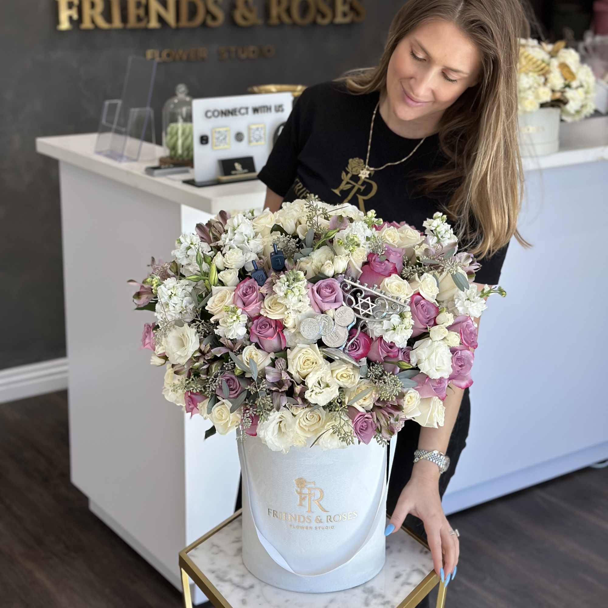 Large pink and white rose arrangement in a white hatbox