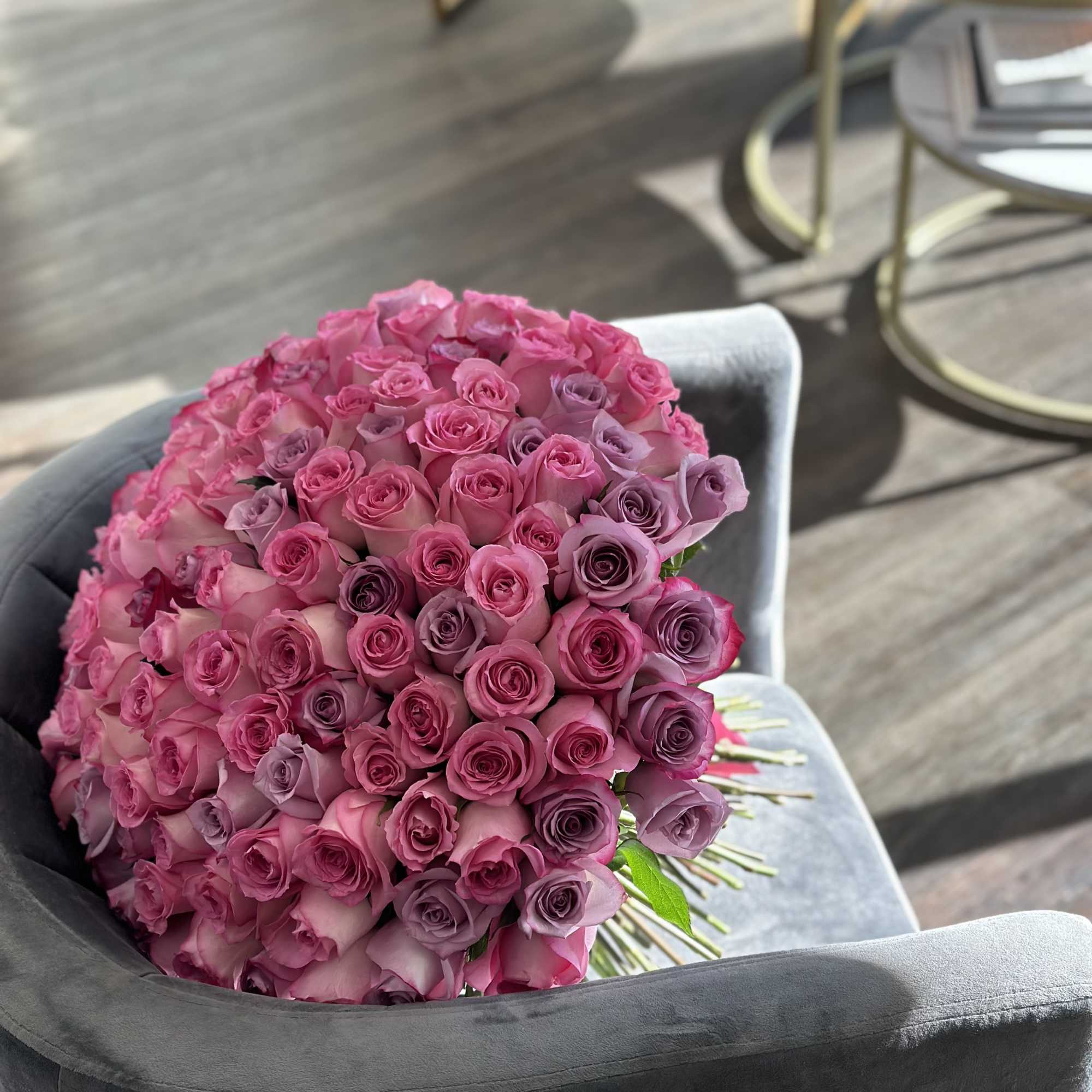 Large bouquet of pink and lavender roses resting on a chair