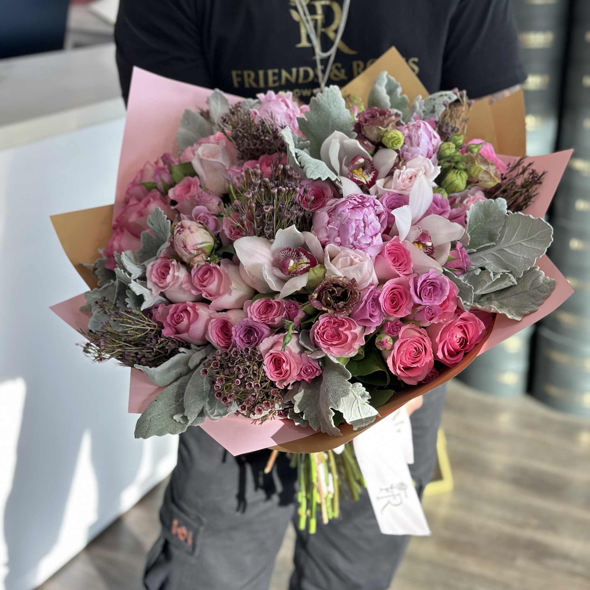 Large pink bouquet with roses and orchids wrapped in paper
