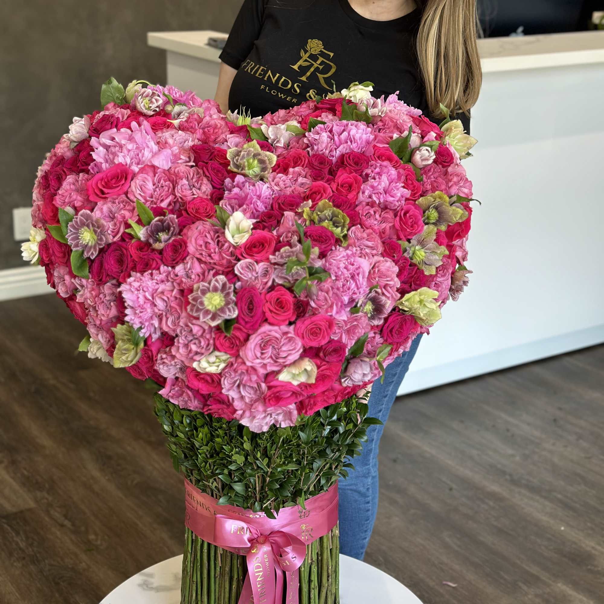 Heart-shaped bouquet of pink roses and hydrangeas with a ribbon wrap