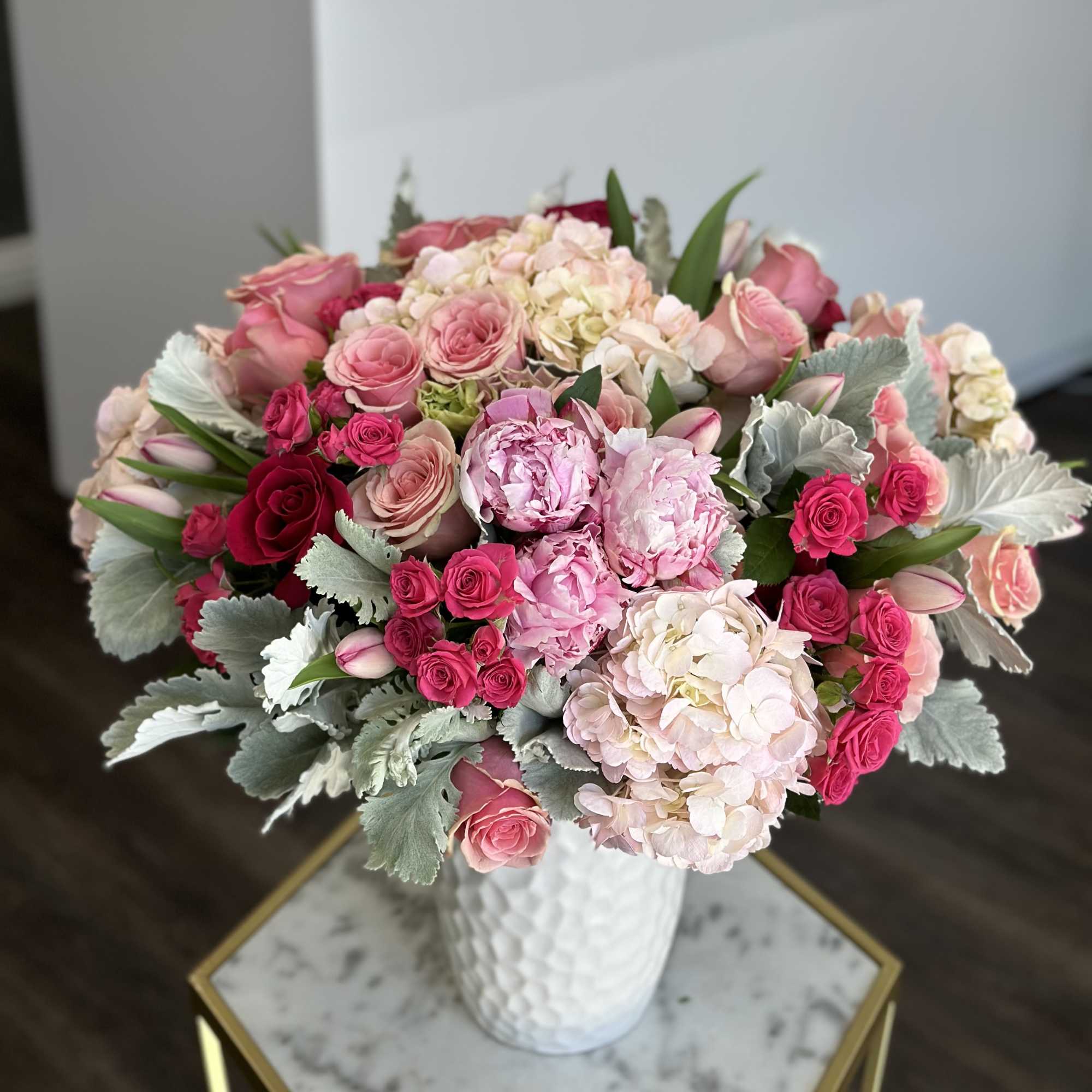 Pink and white rose bouquet with hydrangeas in a white vase
