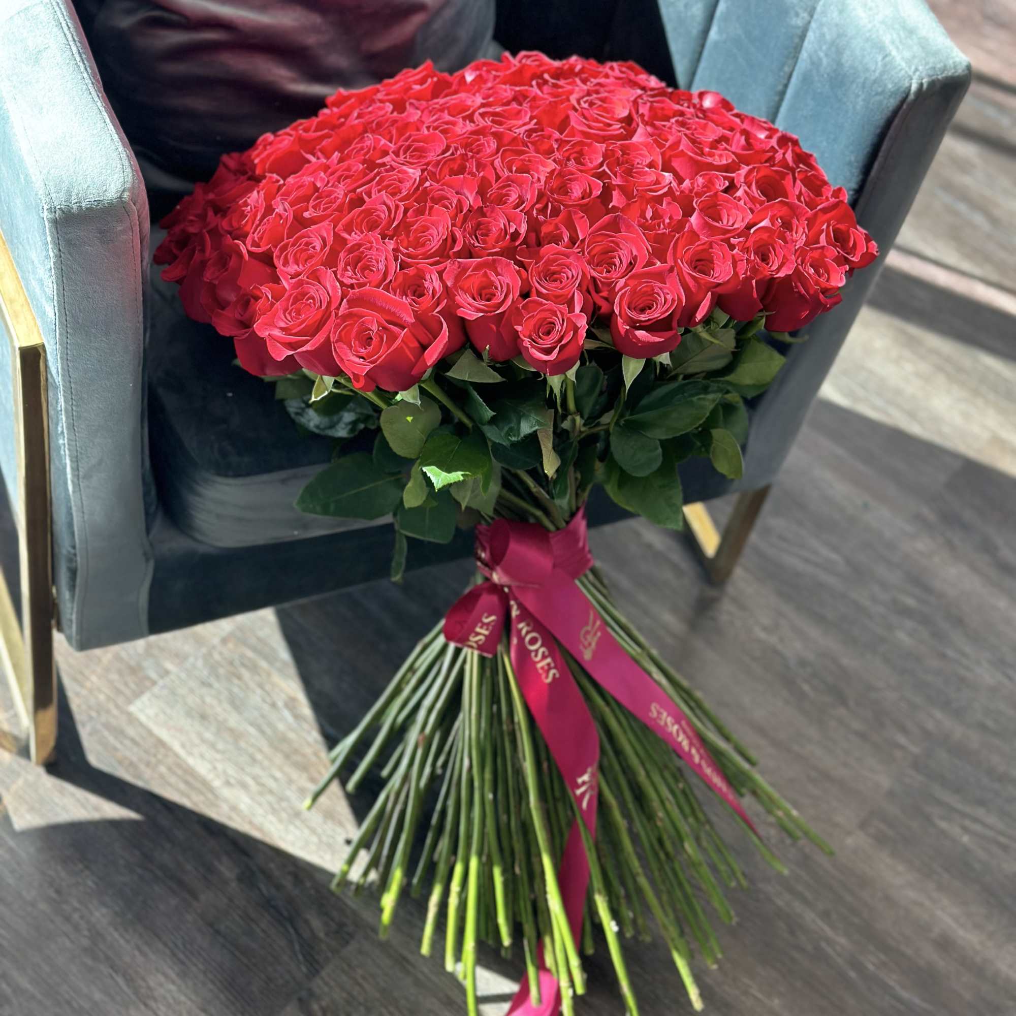 Large bouquet of red roses tied with a pink ribbon