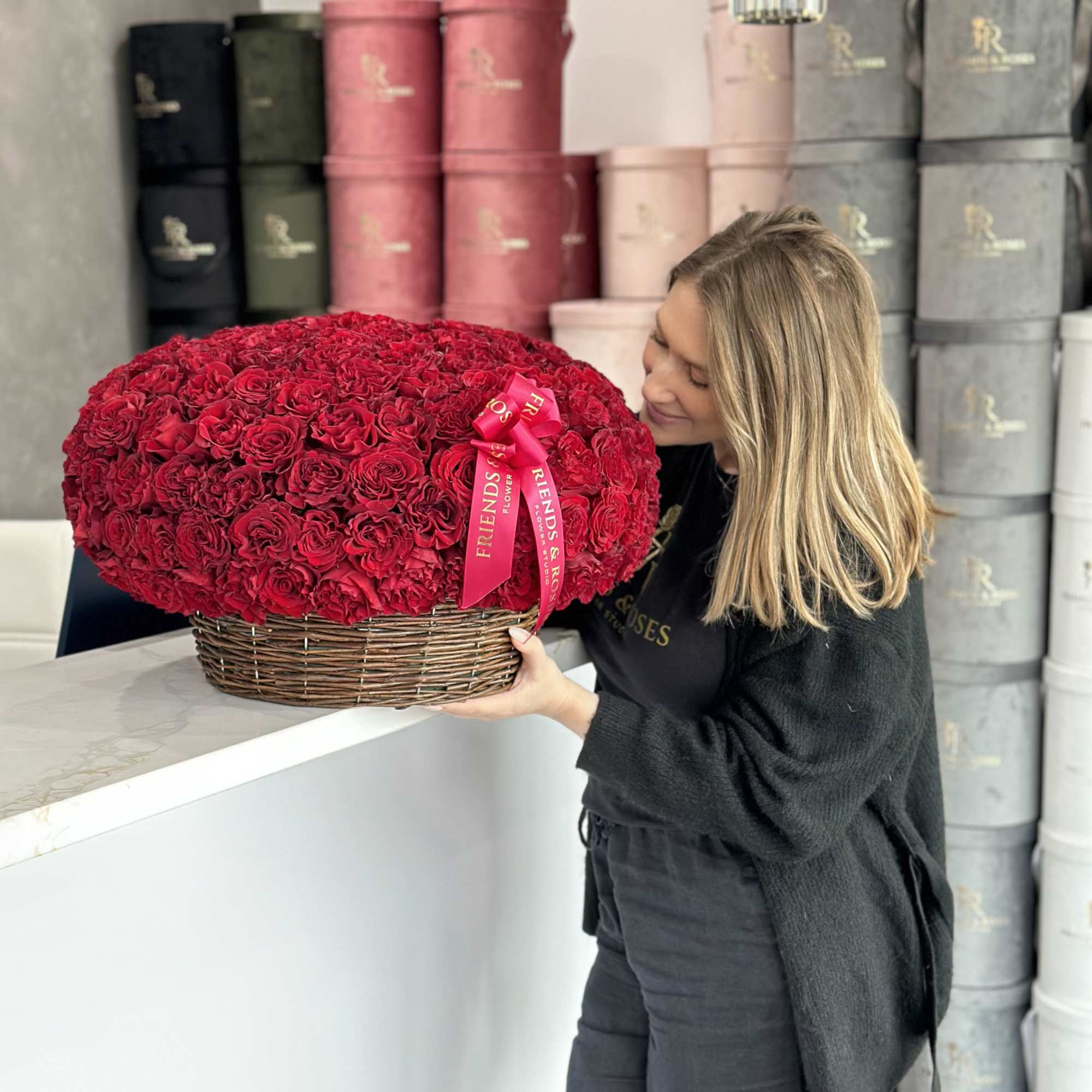 Large basket of red roses with a pink ribbon