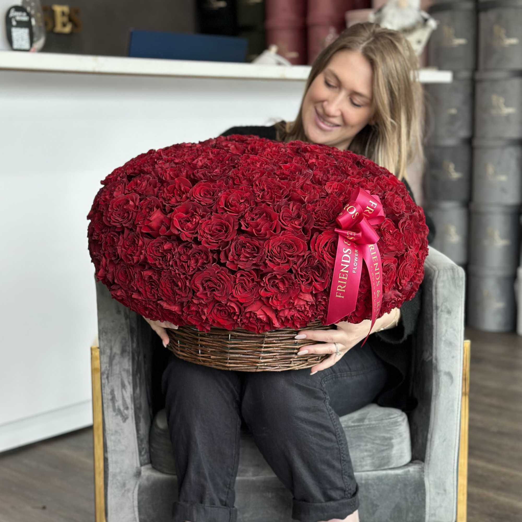 Large basket of red roses held by a woman