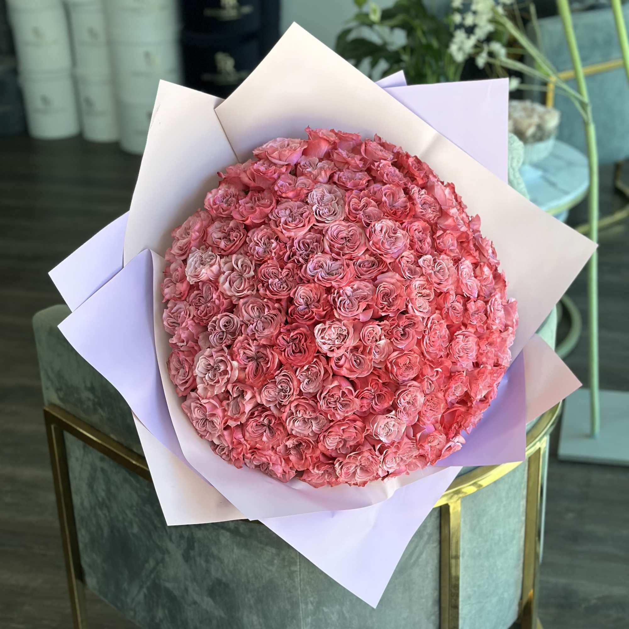Large round bouquet of pink roses wrapped in pastel paper