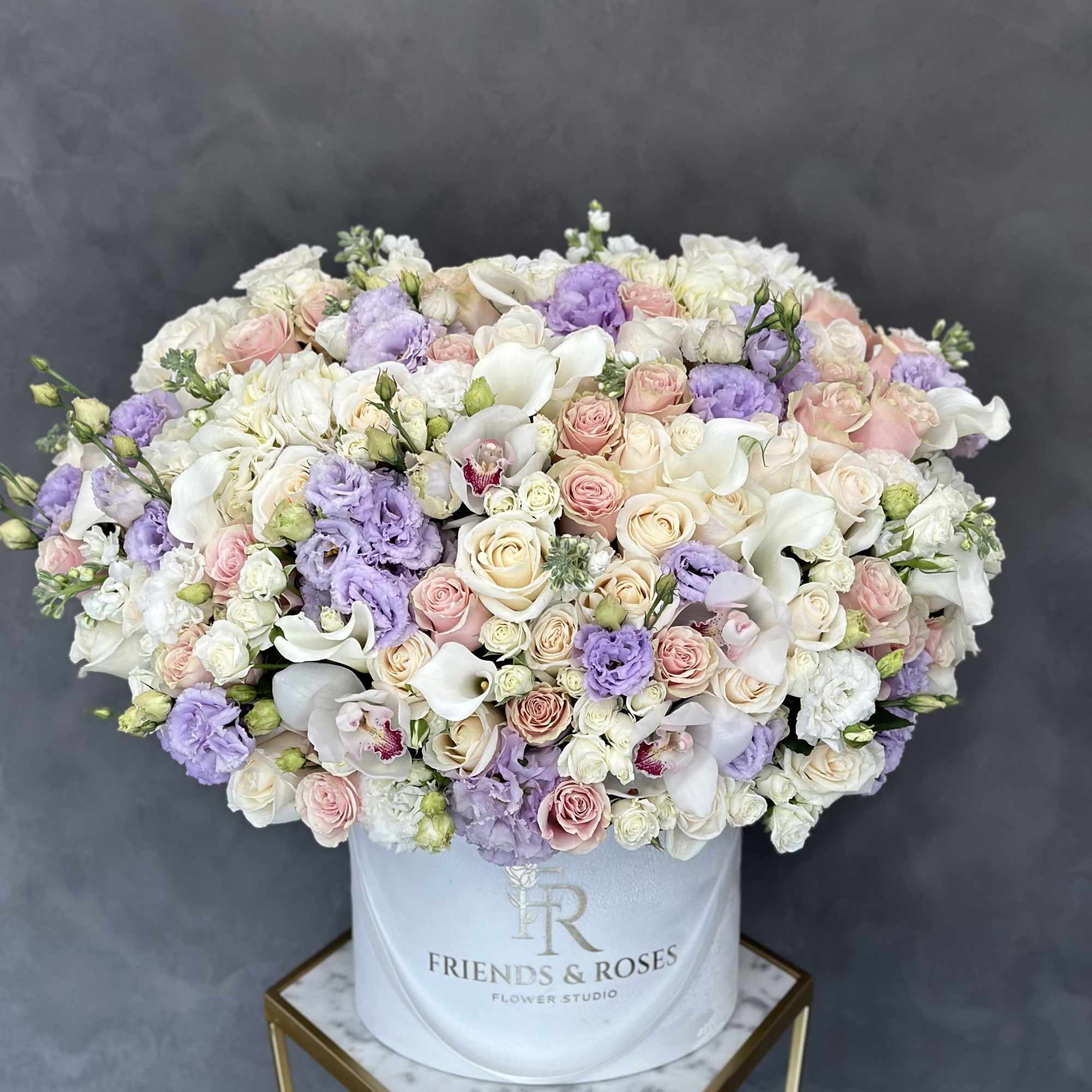 Large pastel bouquet of roses, orchids, and calla lilies in a white hat box, photo 2 of 2