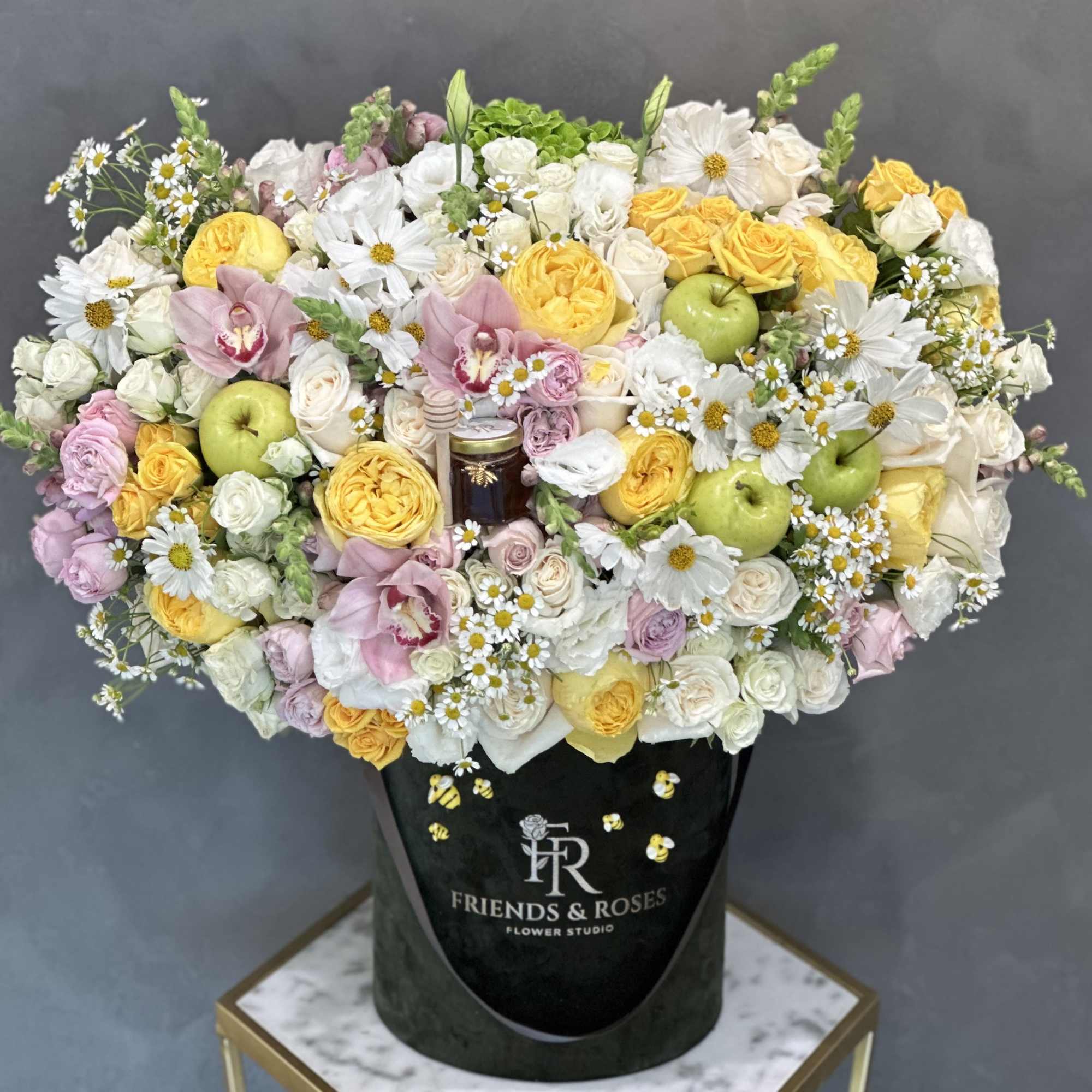 Large mixed bouquet with yellow and white flowers in a black hatbox