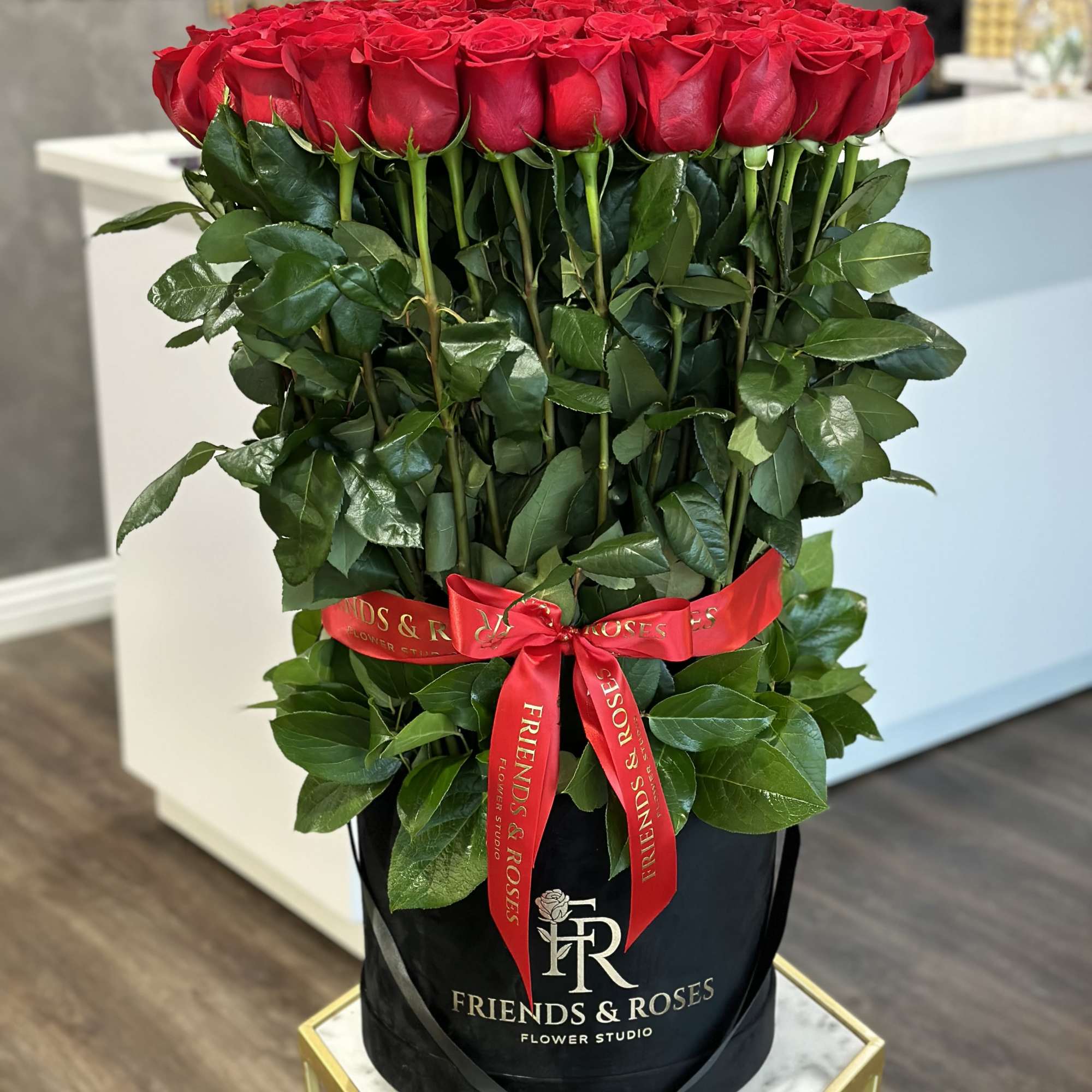 Large bouquet of red roses in a black hatbox with a red ribbon, photo 2 of 3
