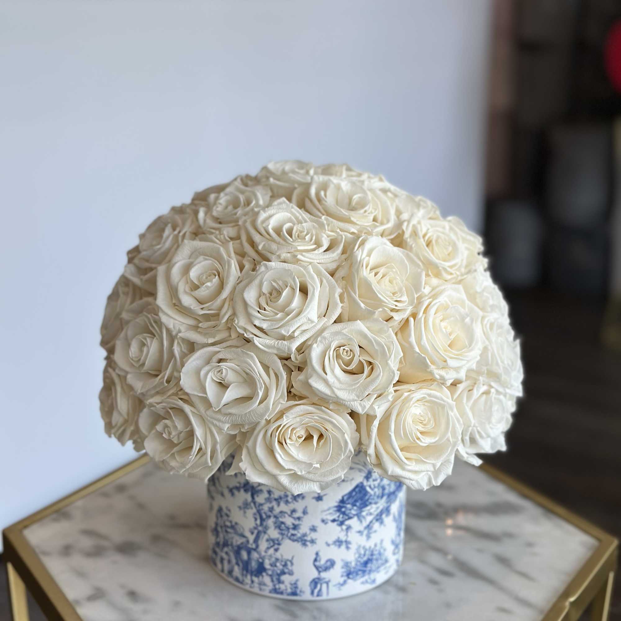 Round bouquet of white roses in a blue-and-white ceramic container