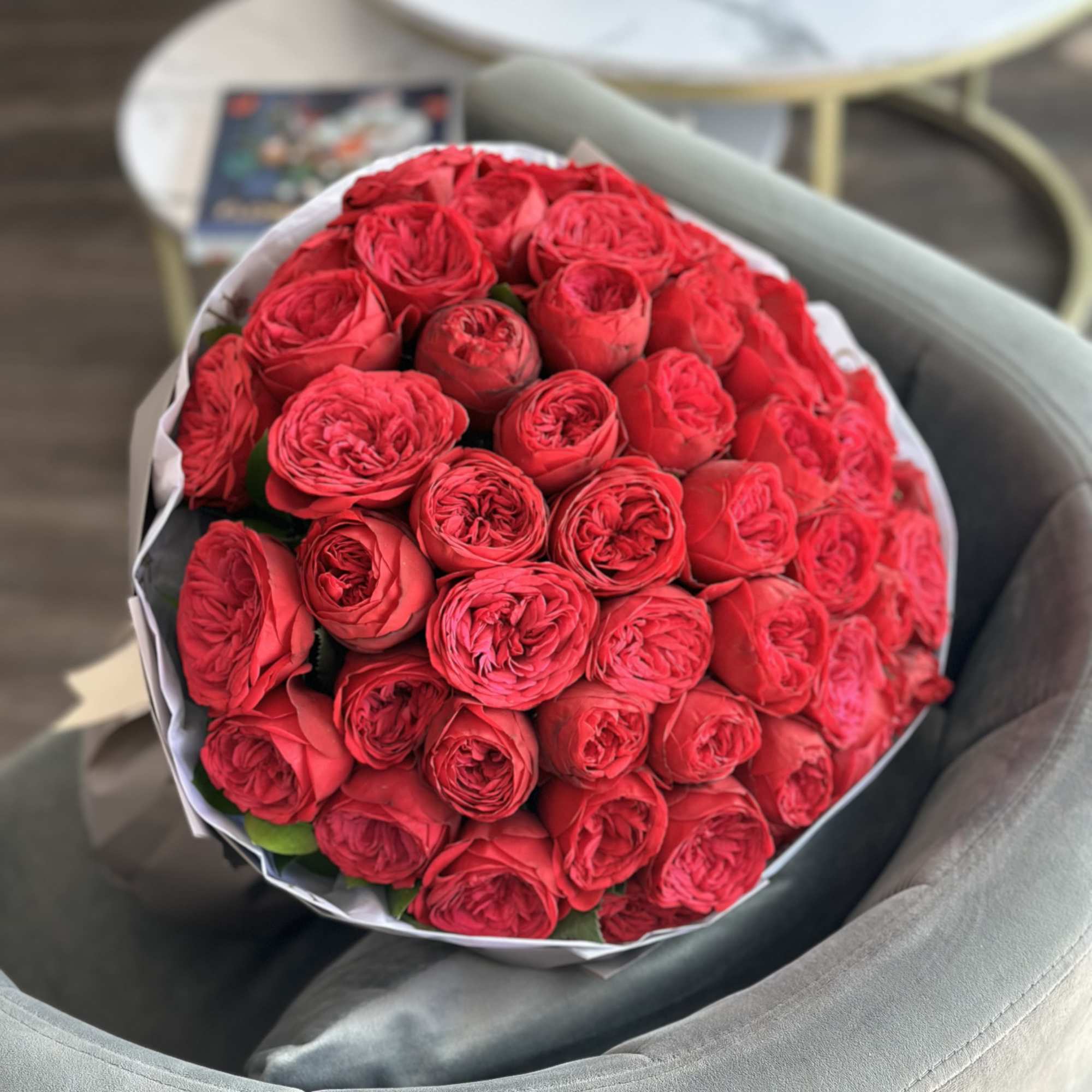 Large bouquet of red roses wrapped in white paper