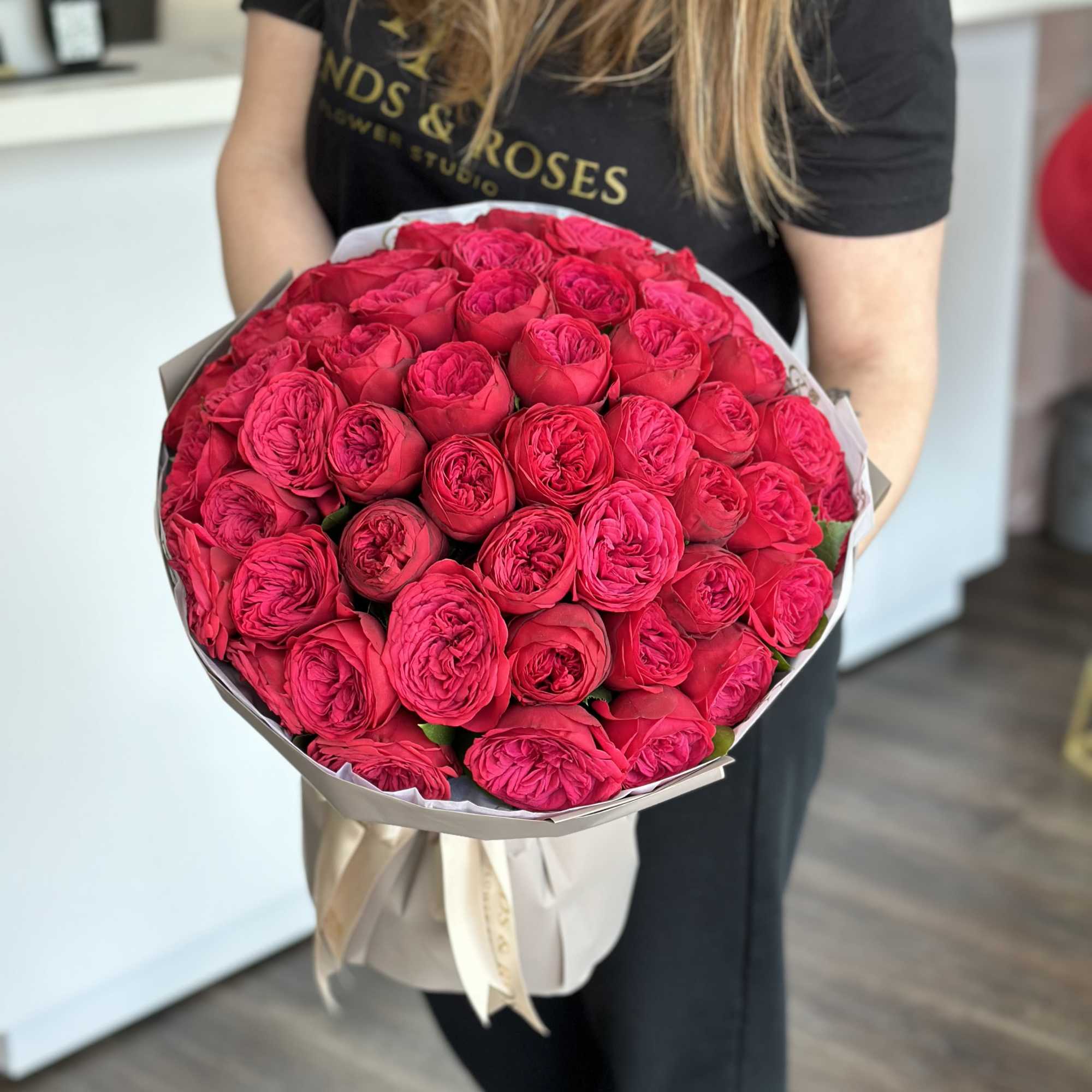 Large bouquet of bright pink roses wrapped in paper
