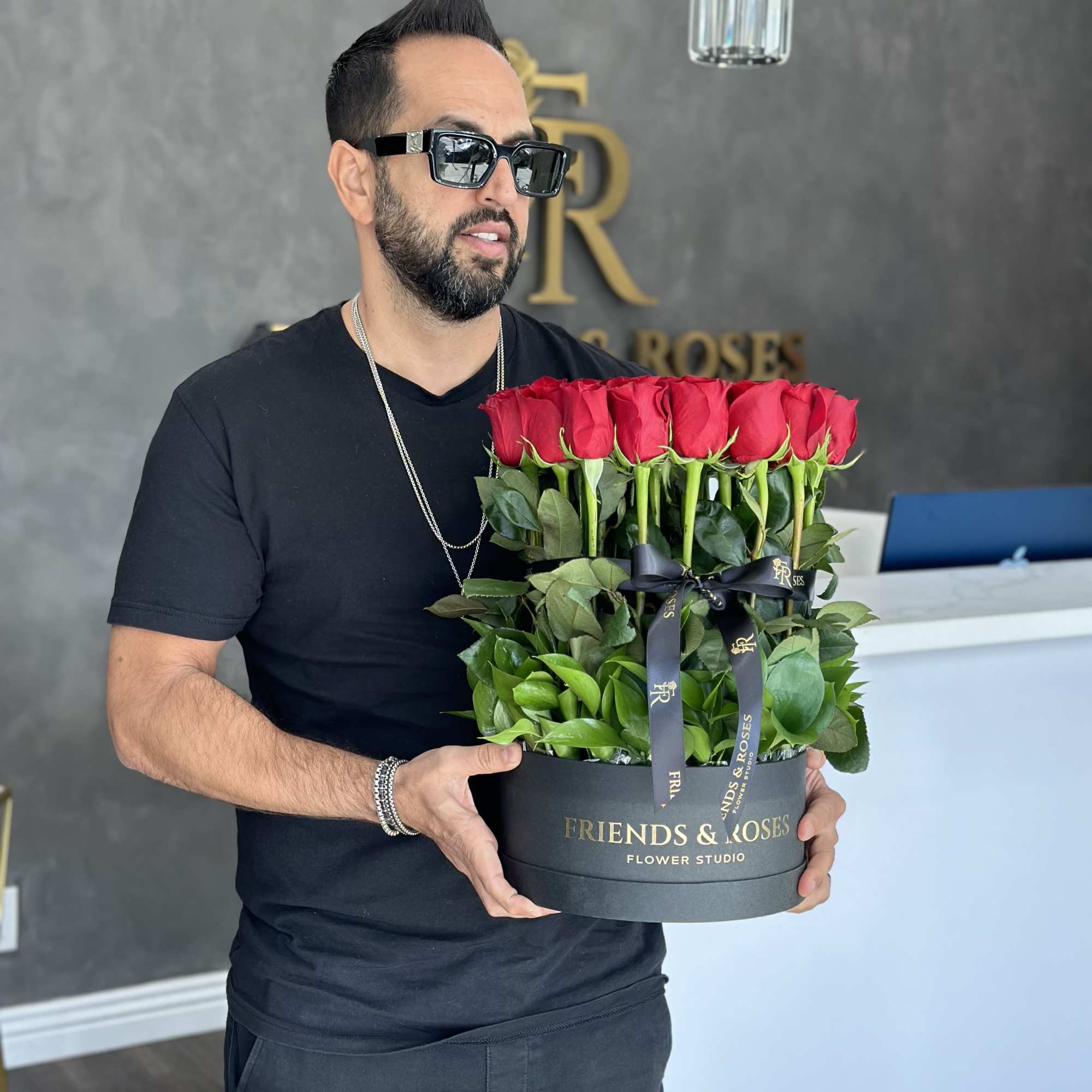 Man holding a black box of red roses