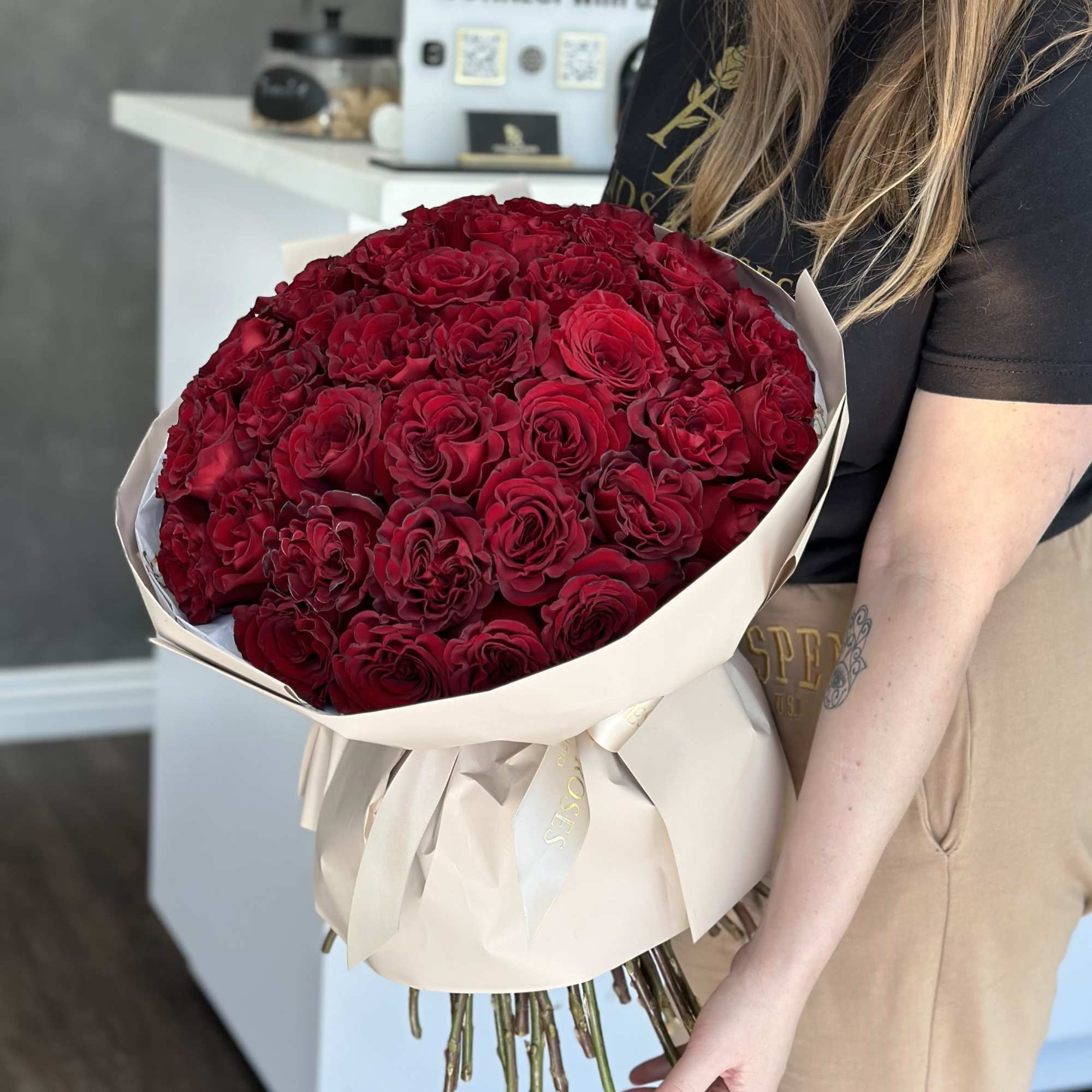 Large bouquet of deep red roses wrapped in cream paper