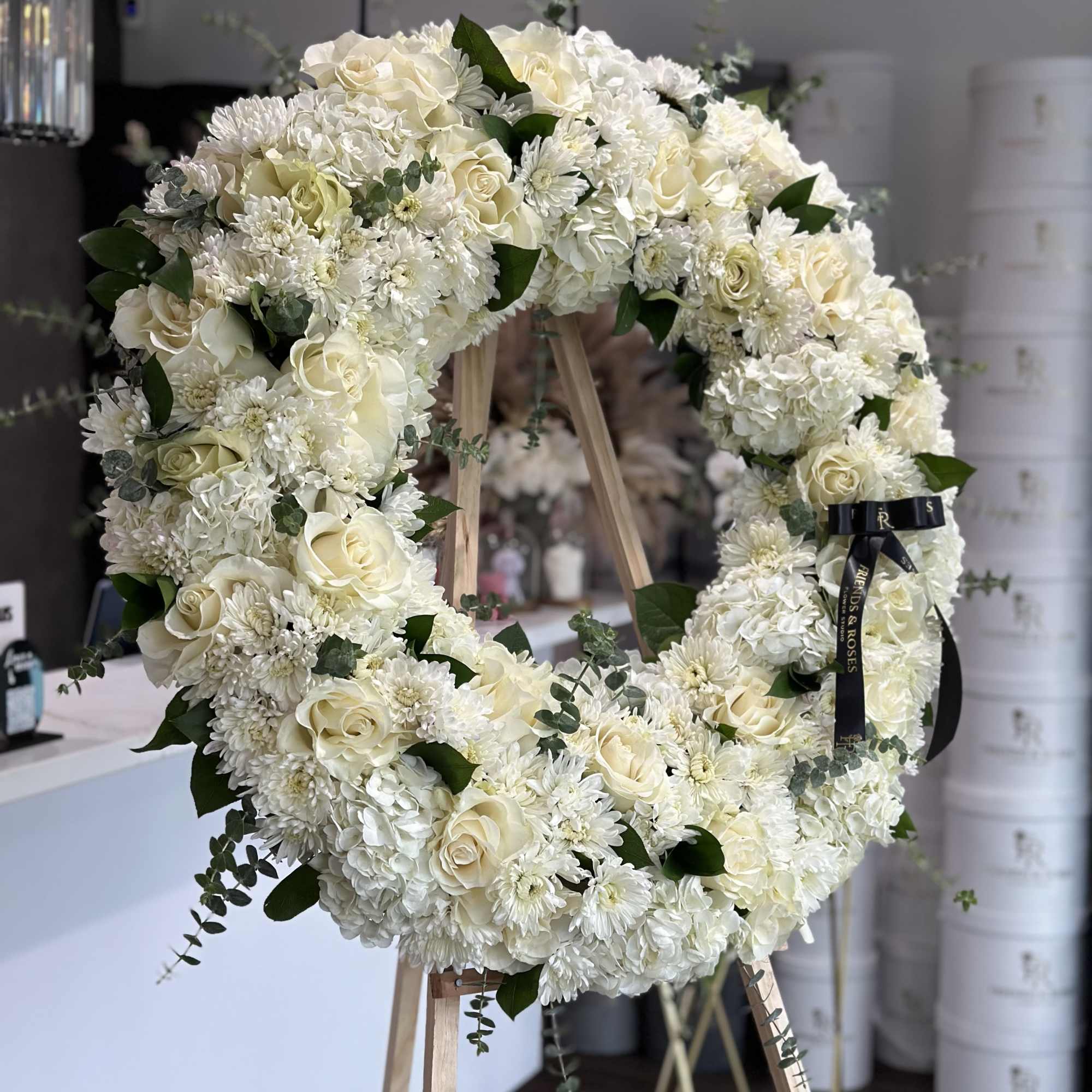 Large white floral wreath on a wooden easel