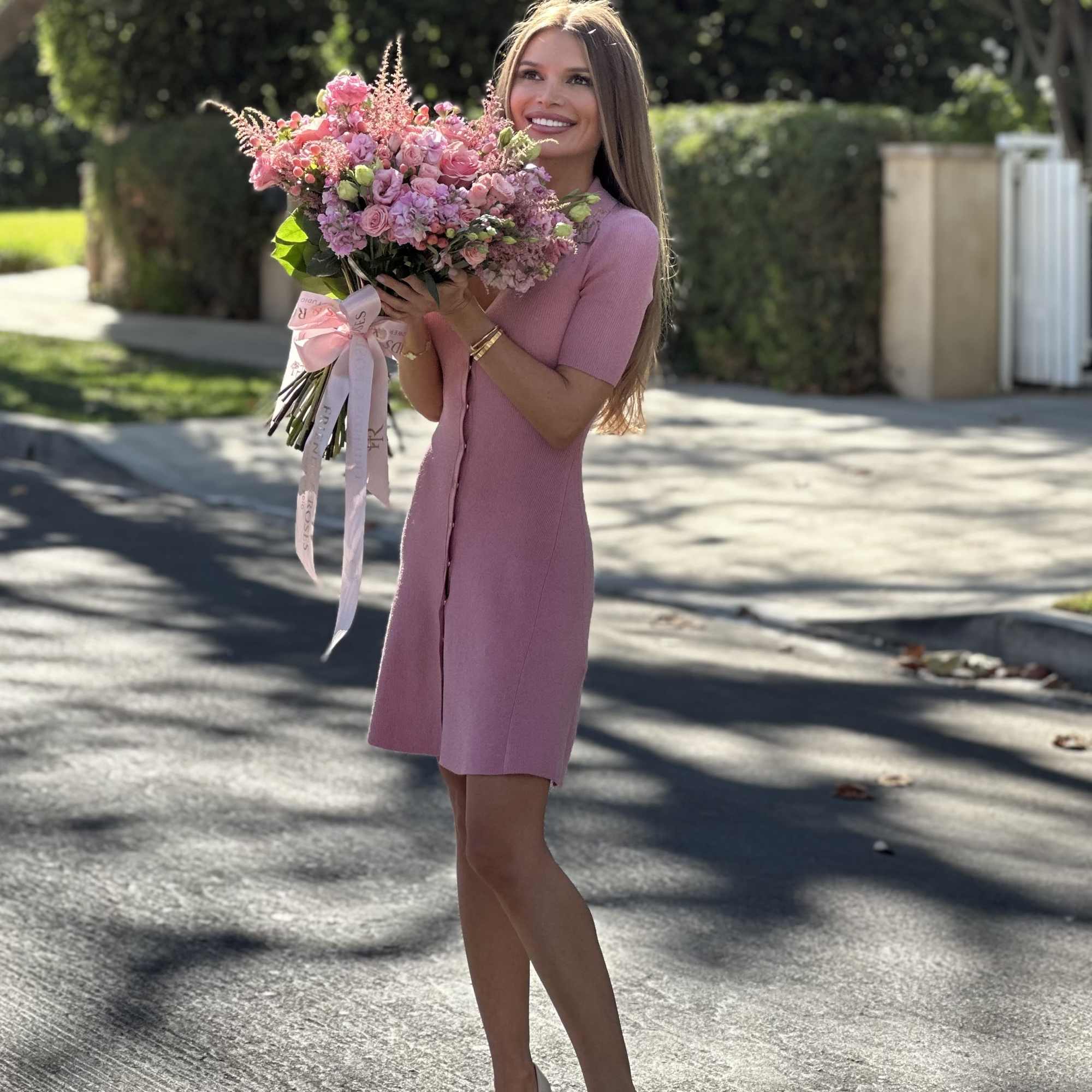Woman holding a large pink bouquet outdoors, photo 3 of 4