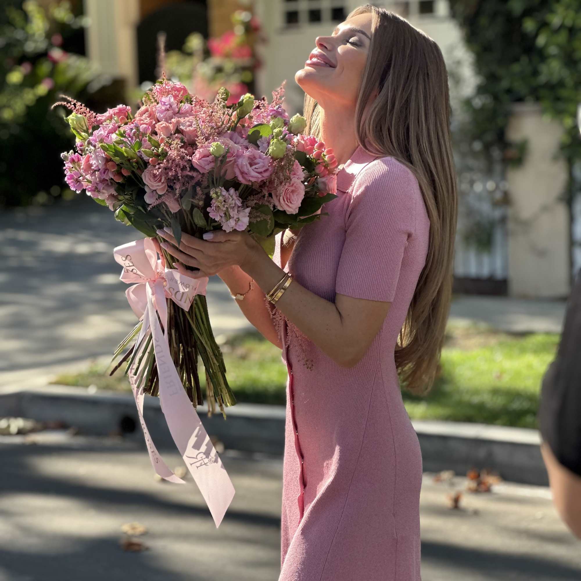 Woman holding a large pink bouquet outdoors, photo 4 of 4