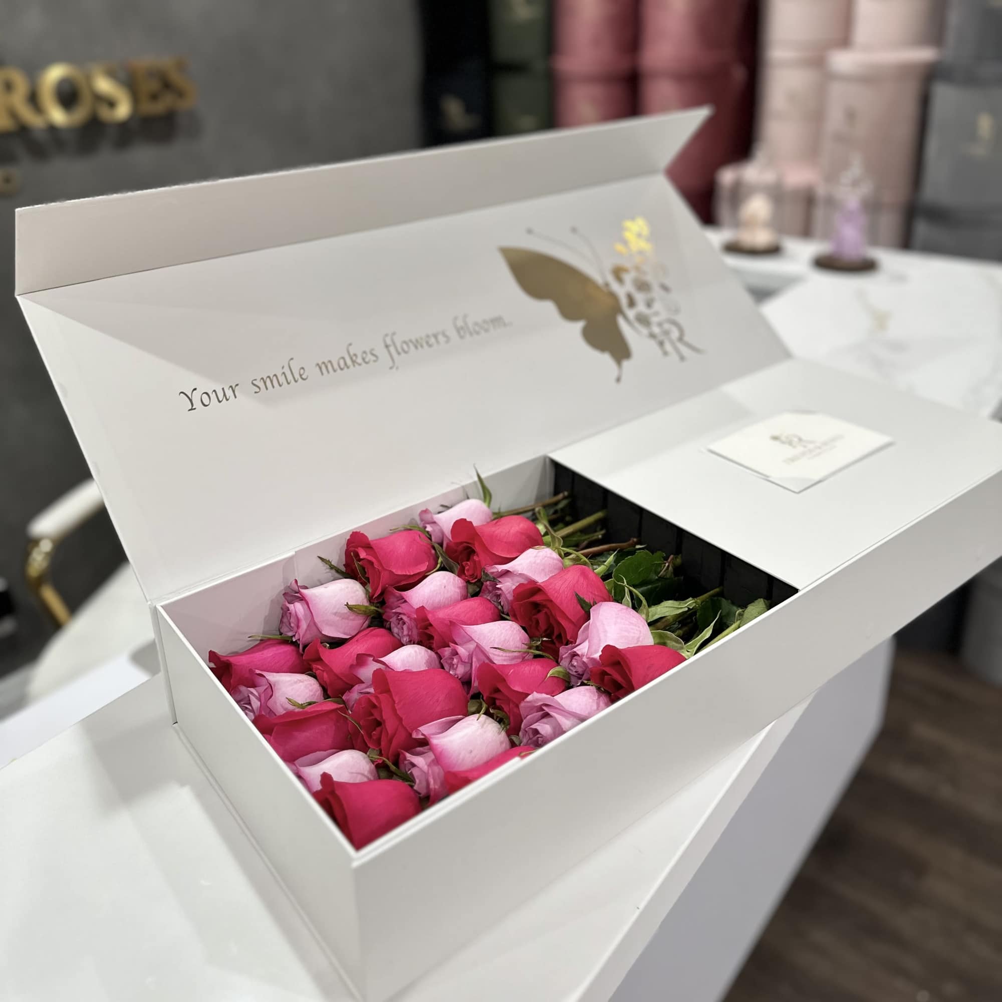 Open white box filled with pink and red roses