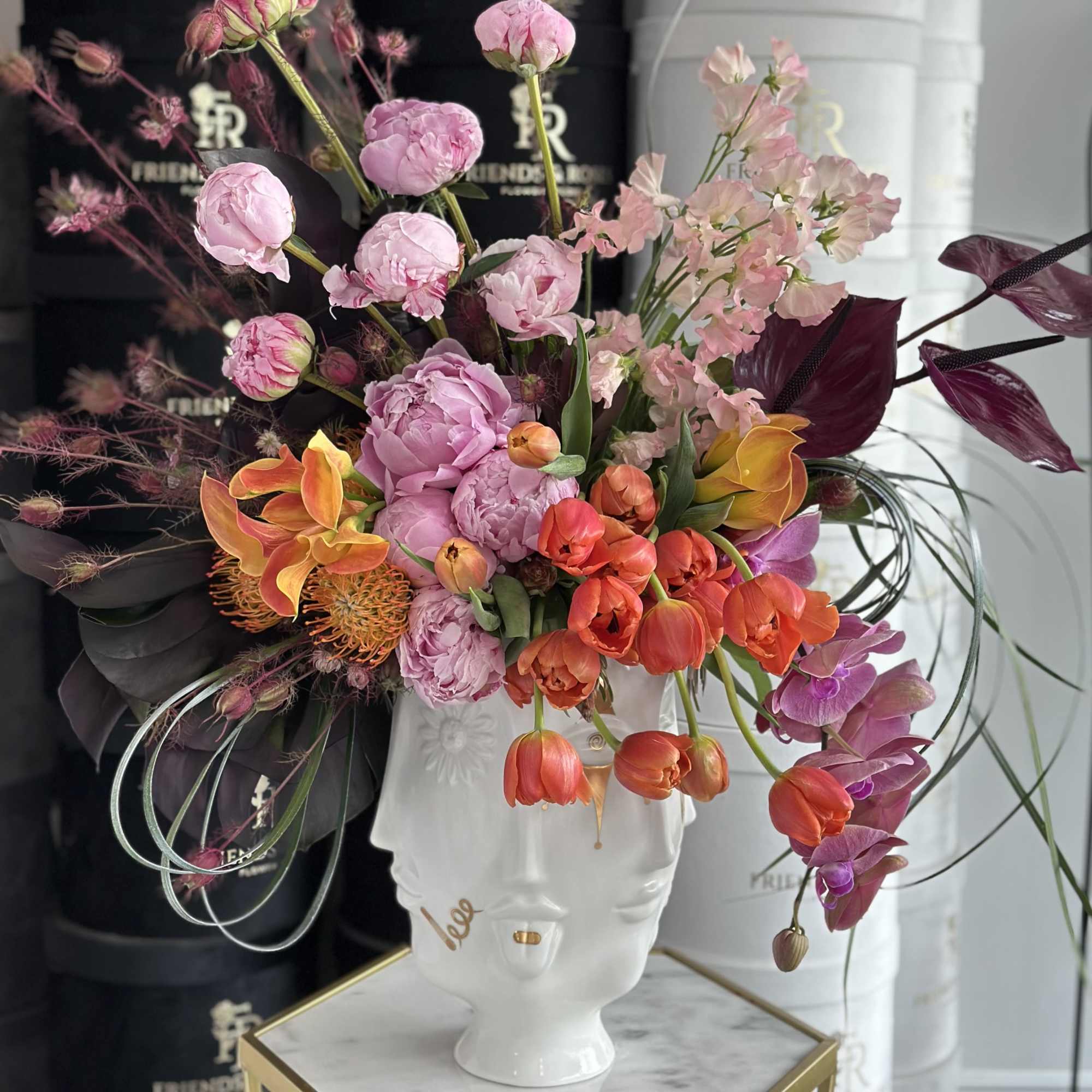 Colorful floral arrangement in a white face-shaped vase