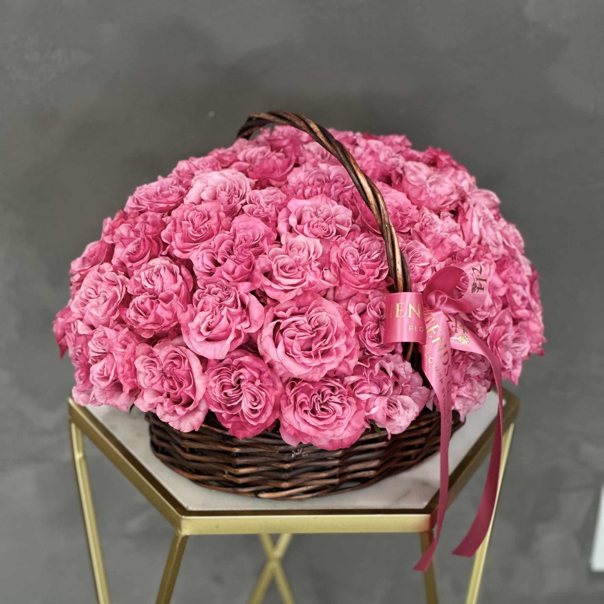 Basket of pink roses with a ribbon bow