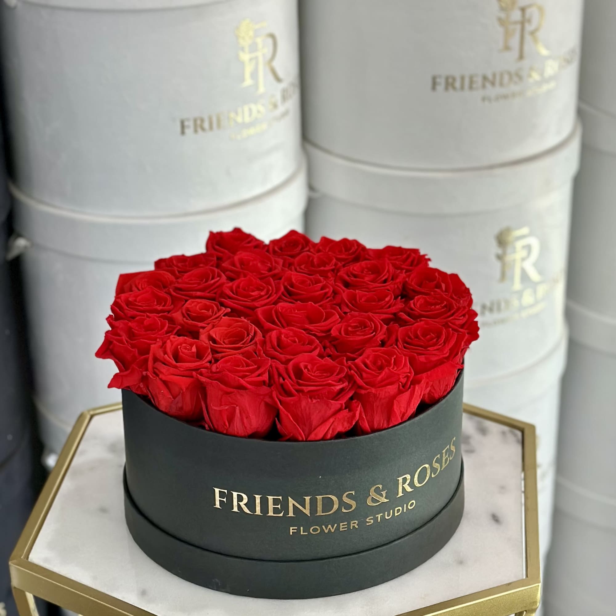 Round box of red roses in a black container