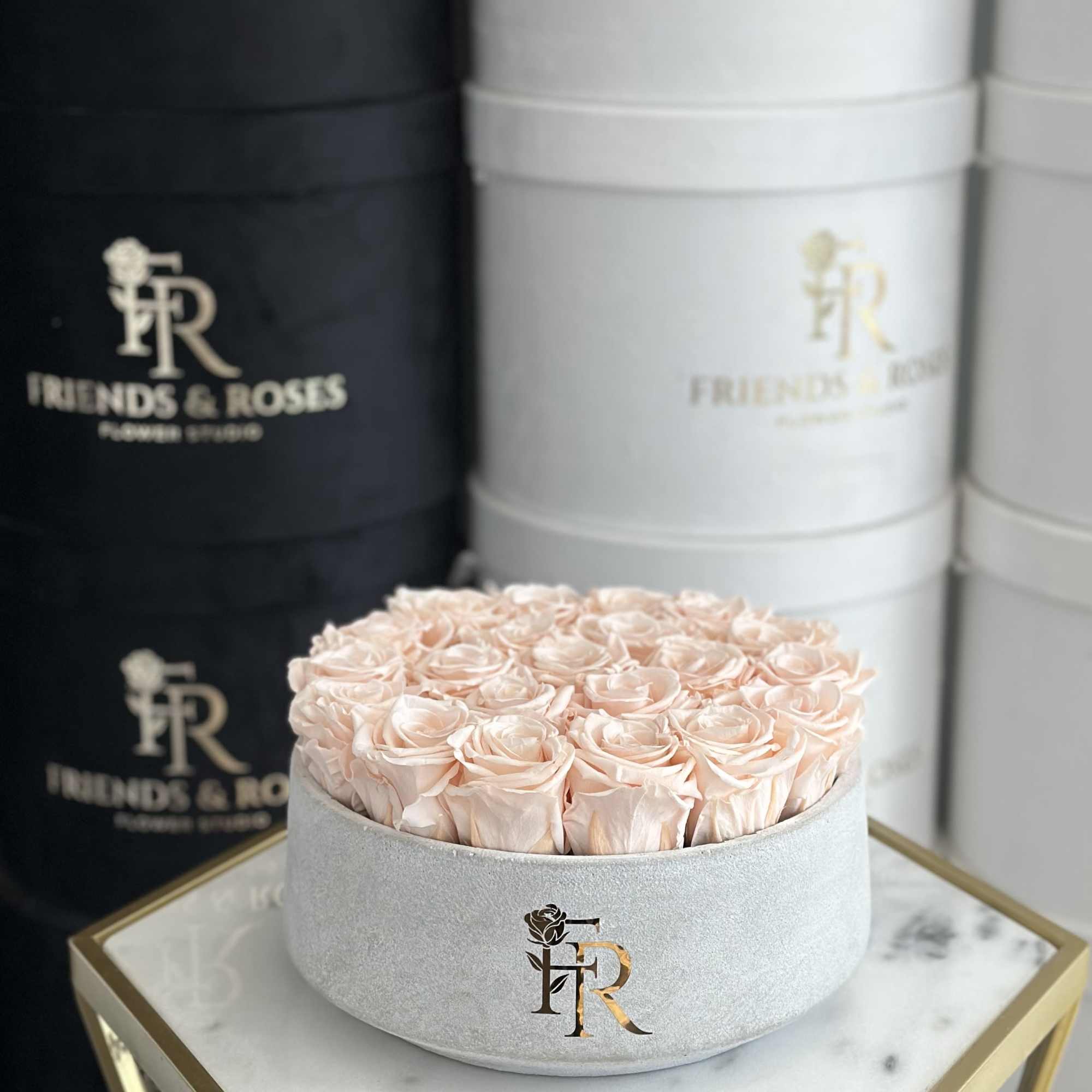 Round box of pale pink roses on a marble tray
