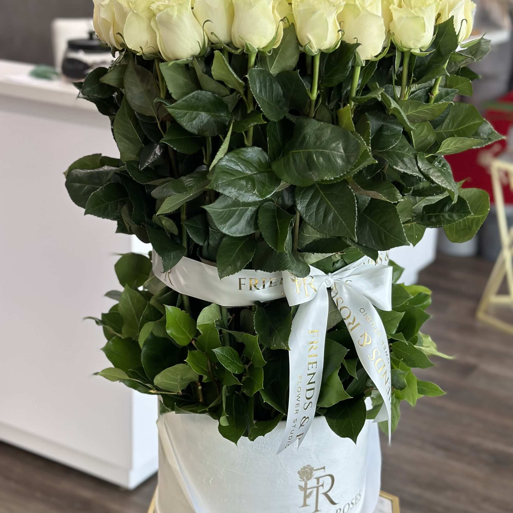 Tall box arrangement of white roses with a satin ribbon